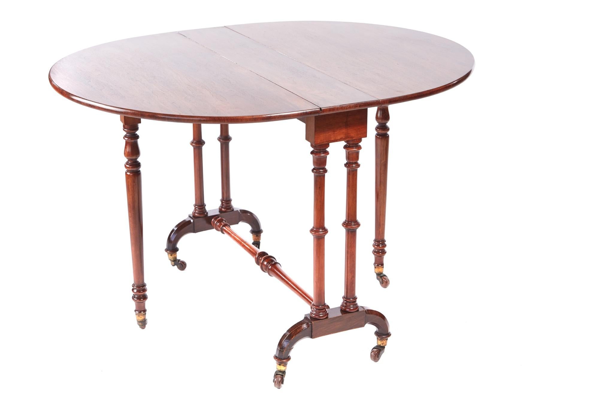 Antique Victorian walnut Sutherland table with oval drop leaves, supported by turned columns, swing out turned gate leg united by a turned stretcher, original castors.

  