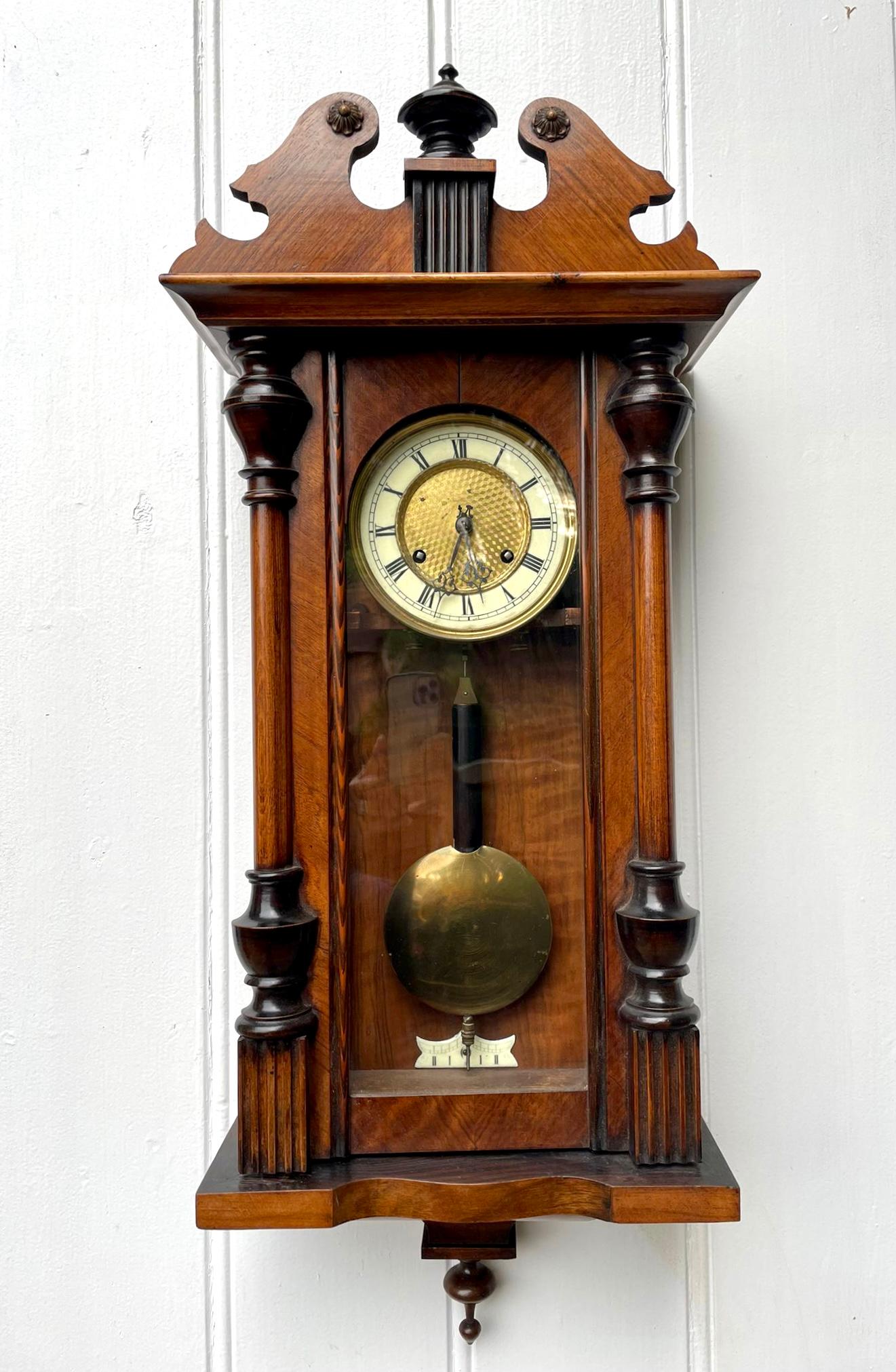 Antique Victorian walnut Vienna wall clock having a shaped swan neck top and a superb quality walnut case with turned columns and original finals, eight day striking movement on the hour and half hour on a gong, round dial with original hands and