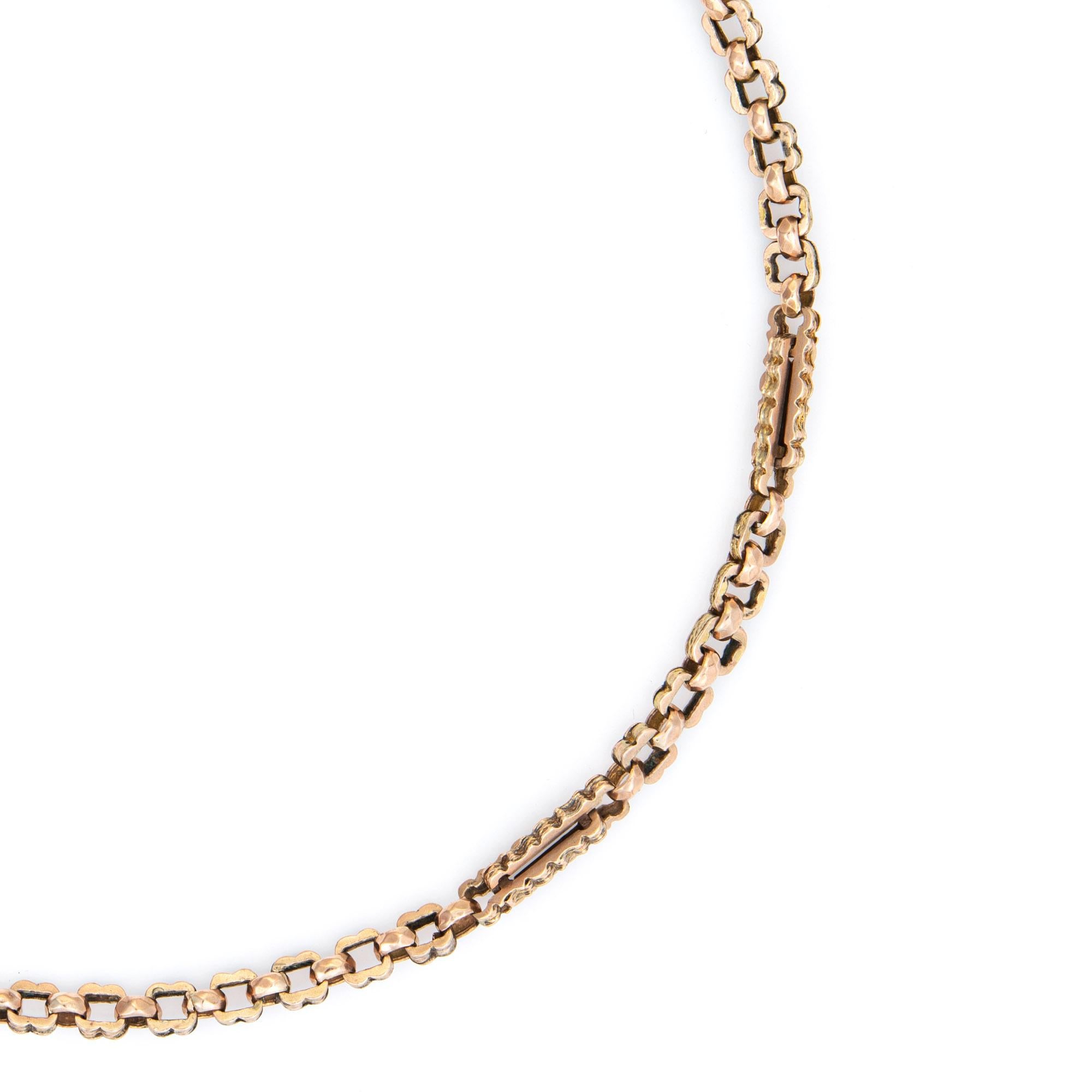 Stylish and finely detailed antique Victorian watch chain necklace crafted in 9k rose gold (circa 1880s to 1900s).  

The fancy link necklace features elongated links with repeating rows of textured design, crafted in rosy 9k gold. Originally a