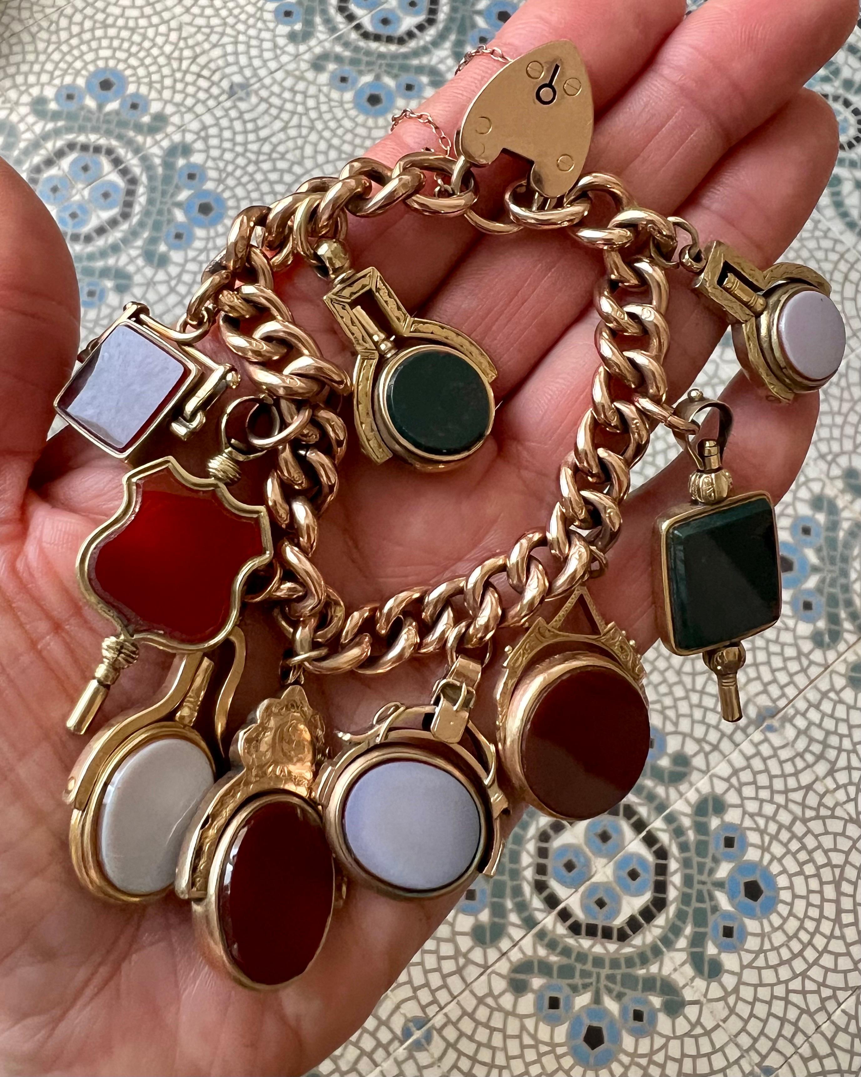 Uno squisito bracciale vittoriano antico con catena a cordoncino in oro 9ct risalente al XIX secolo, caratterizzato da nove unici ciondoli, cinque dei quali a forma di chiave d'orologio. I sette fob possono essere ruotati e sono tutti incastonati
