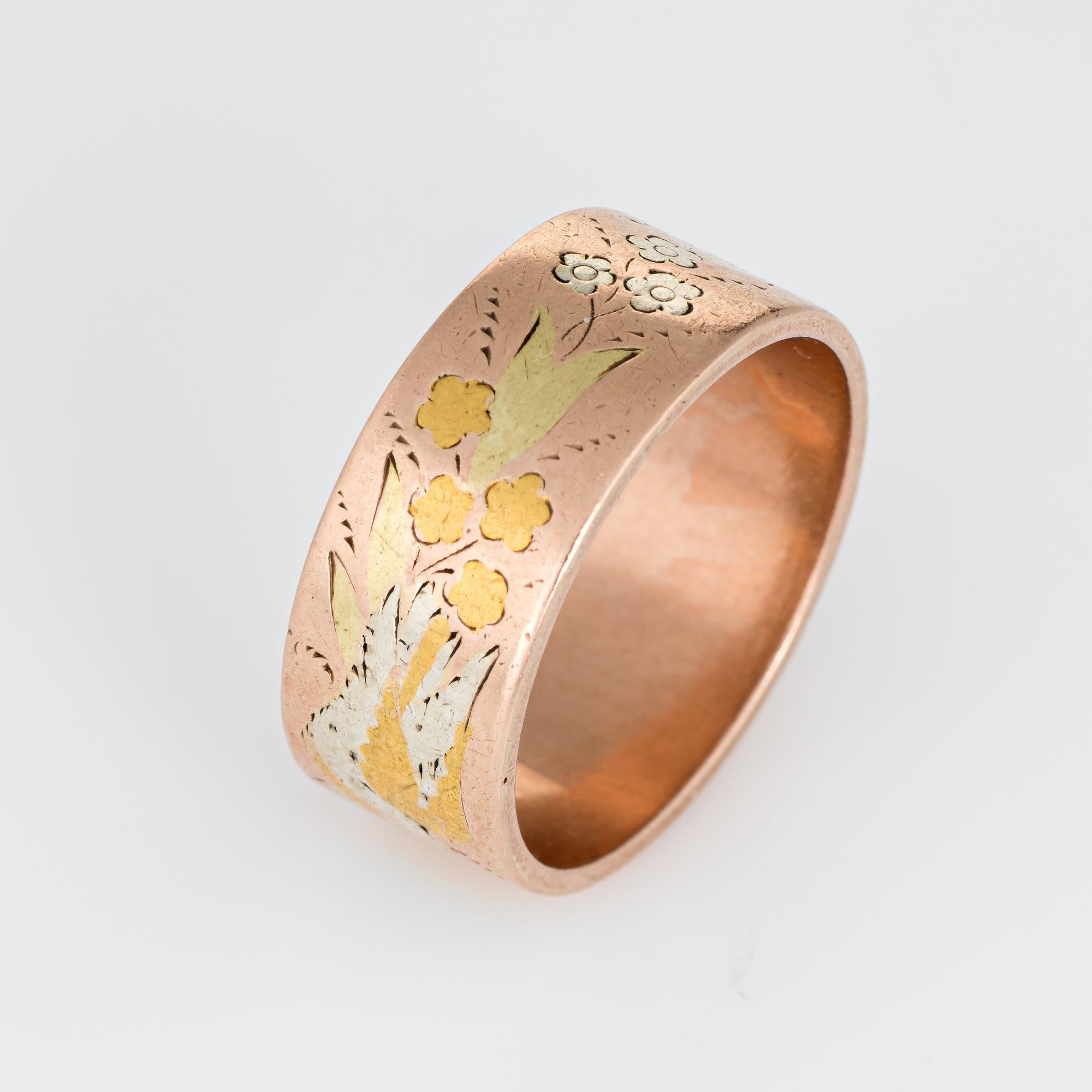 Elegant antique Victorian wedding band (circa 1880s to 1900s) crafted in tow-tone 14k rose & yellow gold. 

The band features a pattern of flowers and leaves with two white doves rendered in silver. The ring epitomizes vintage charm and would make a
