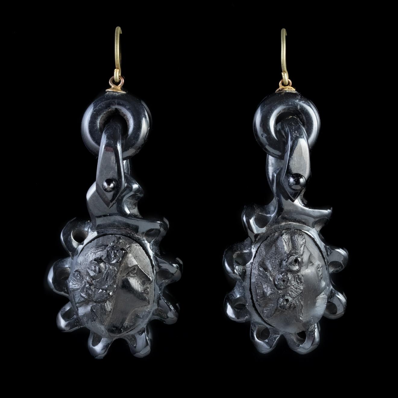An unusual pair of Antique mid-Victorian earrings dating Circa 1860. The earrings are hand carved from Whitby Jet and feature a detailed high relief cameo depicting the side portrait of an elegant lady with flowers in her hair. 

Whitby Jet is a