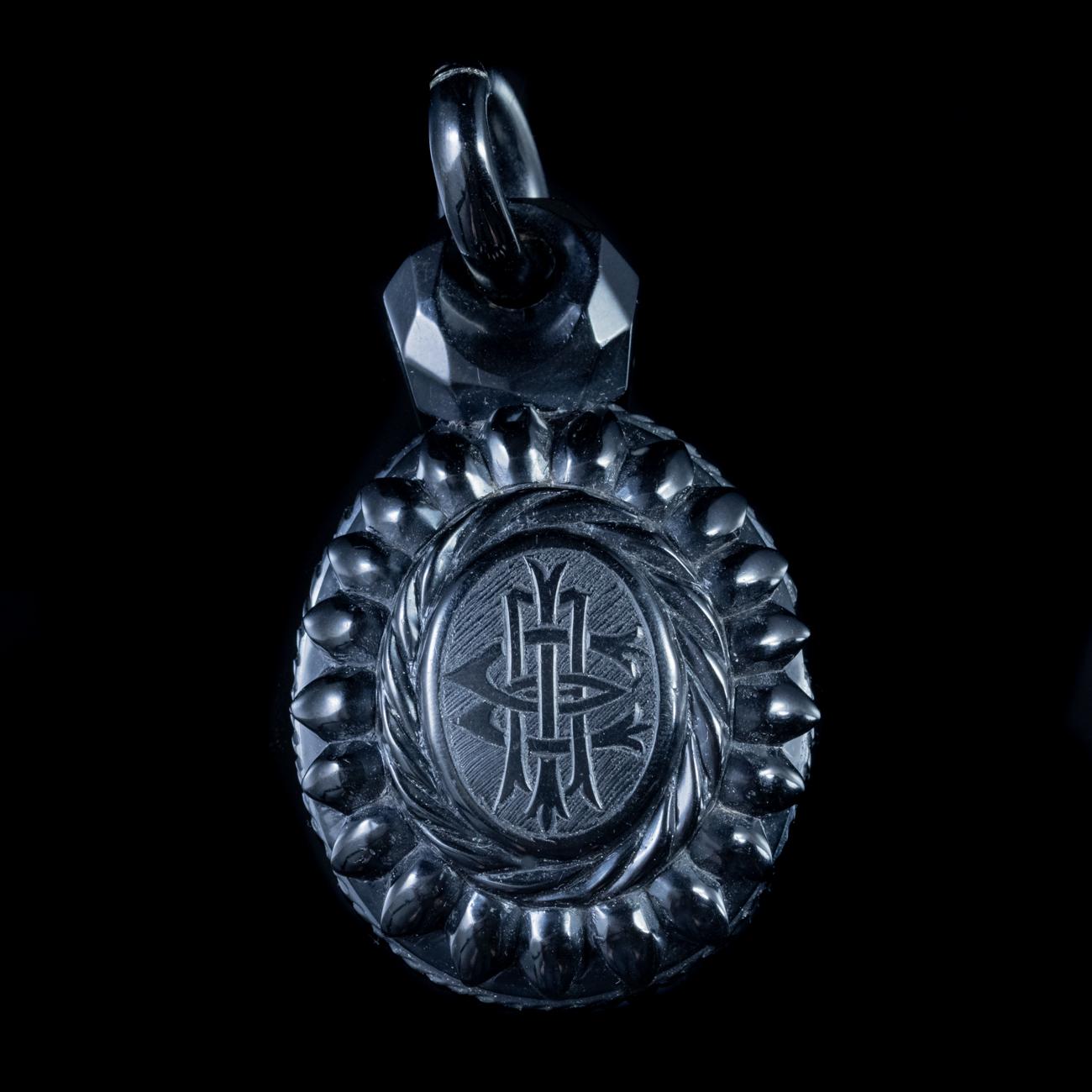 This stunning Antique Victorian pendant locket has been modelled in black Whitby Jet. It is an impressive size and features intricate engravings across the front and edges, as well as a large sculpted bale.

It is in excellent condition all round