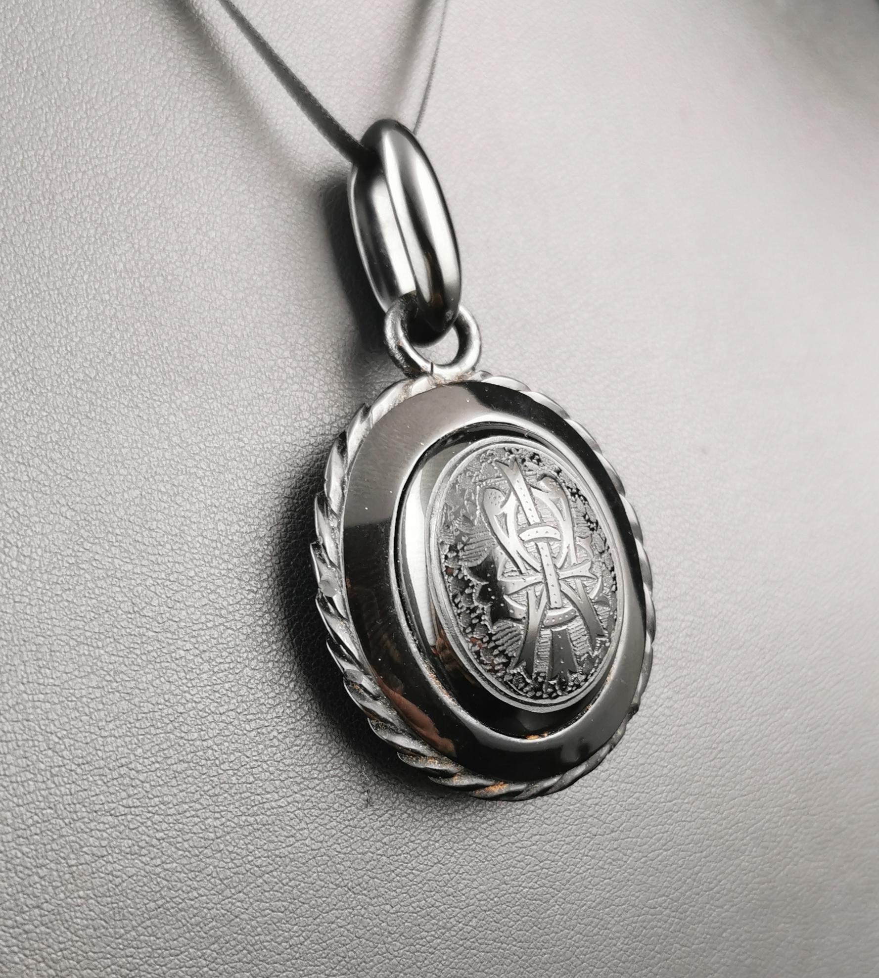 A beautiful antique Victorian era mourning locket.

It is finely hand carved from inky black Whitby Jet, domed at the front with the engraved letters AEI which stand for Amity Eternity Infinity.

This was a popular motif in Victorian jewellery in