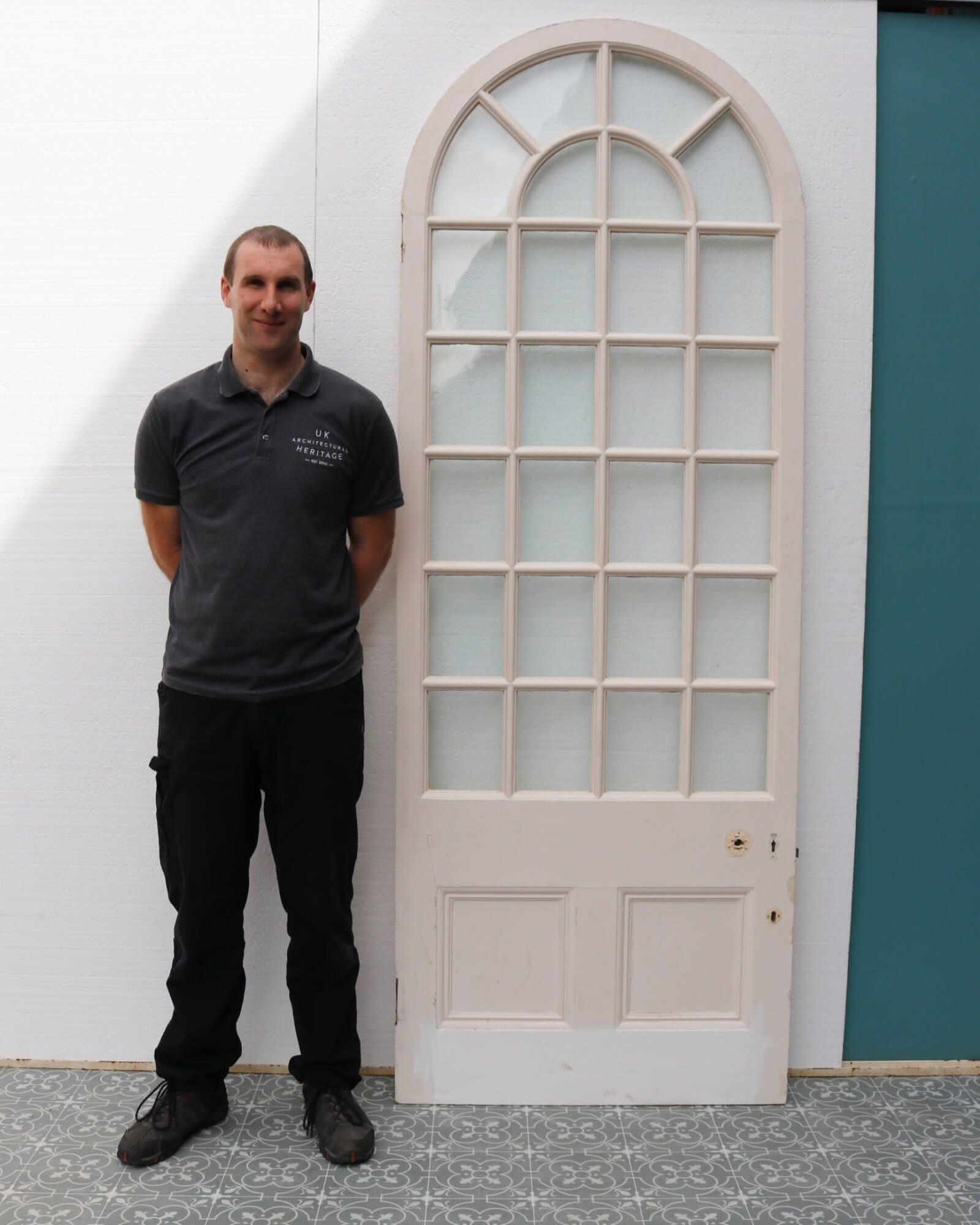 An antique Victorian white arched glazed door suitable for interior use. Dating to circa 1870, this elegant door was sourced from a Victorian orangery in Tetbury, England. It would look stunning in a similar room, such as a conservatory, or sunroom,