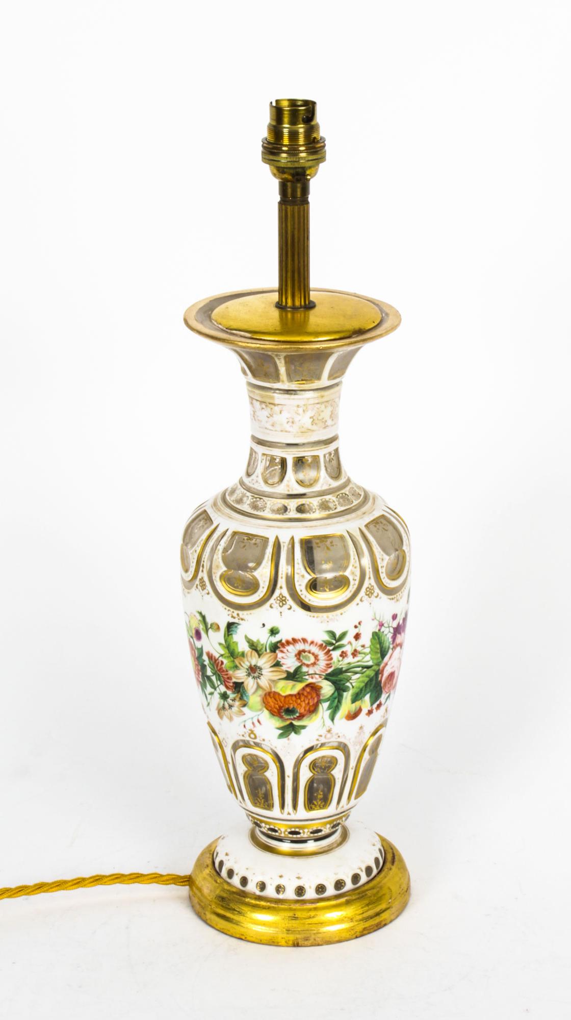 This is an elegant antique Victorian white opaque overlaid glass table lamp, circa 1860 in date.
 
This stylish baluster shaped vase was later converted to an electric lamp, it features cut panel decoration, decorated in gilt and coloured enamels