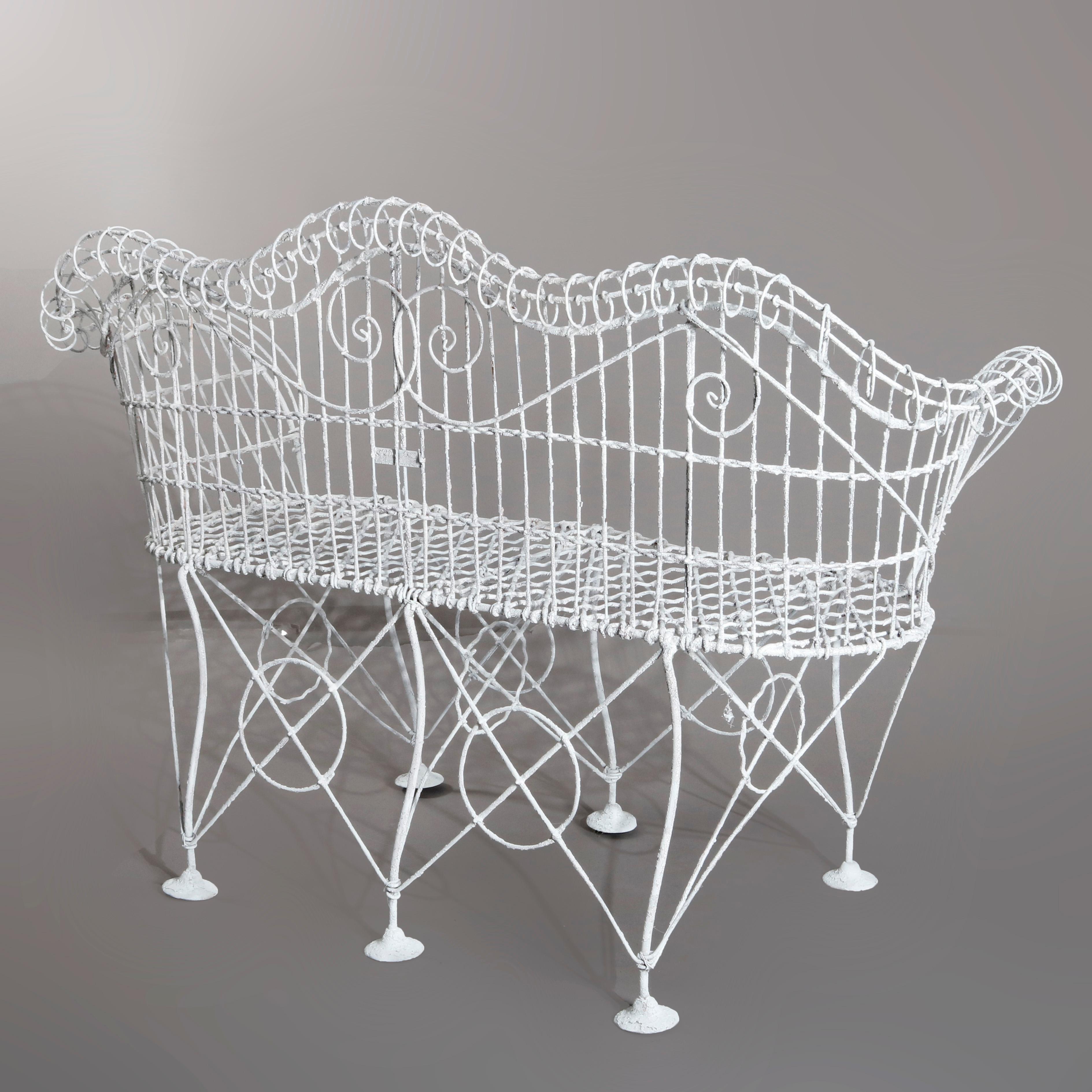 An antique Victorian garden bench offers white painted metal wire construction with shaped scroll form back and arms, circa 1900.

 Measures - 38