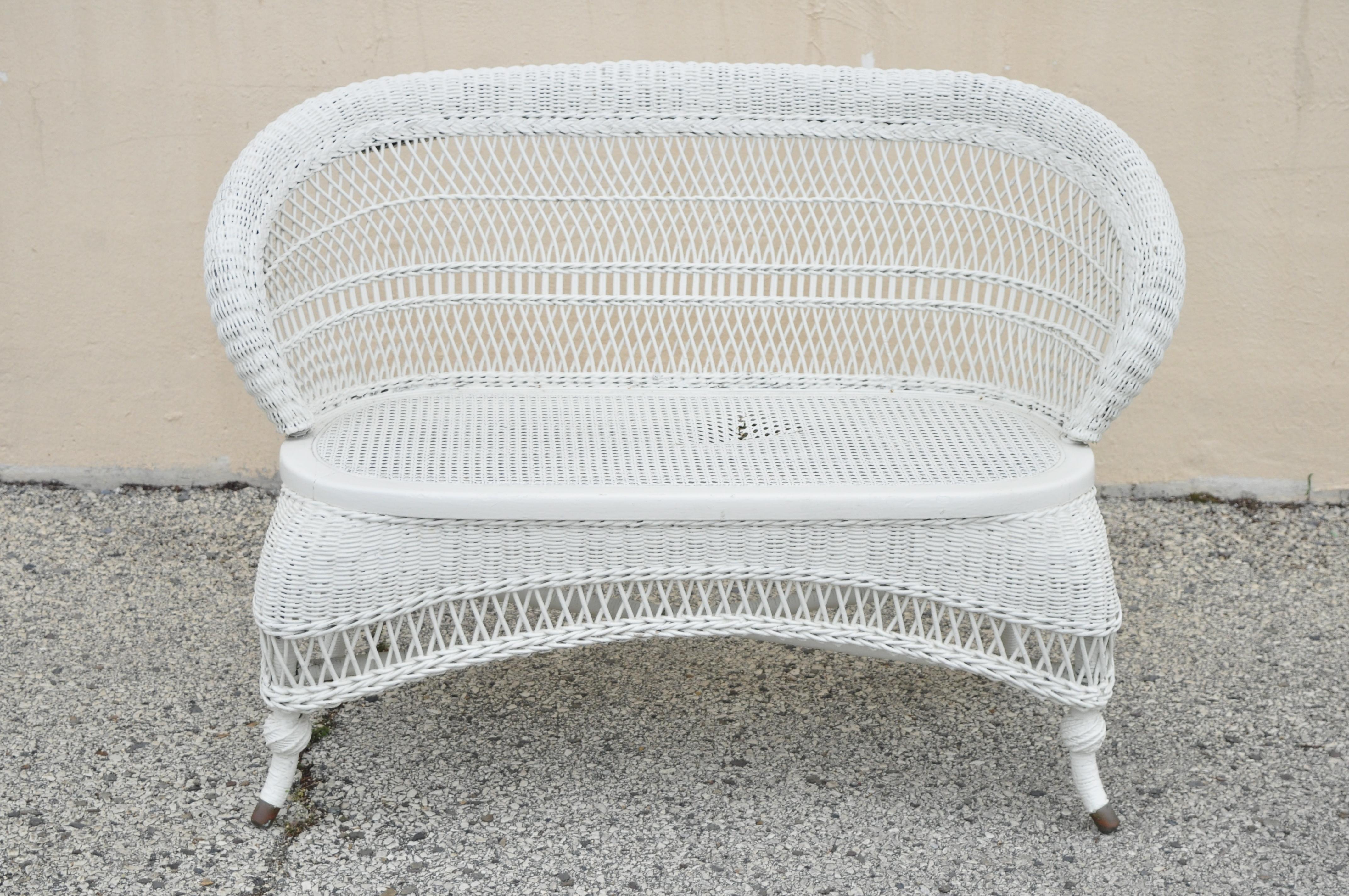 Antique Victorian white wicker barrel back small settee loveseat sofa with cane seat. Item features brass capped feet, nice smaller size, woven wicker frame, cane seat, shapely barrel back, very nice antique item. Circa 1900s. Measurements: 30
