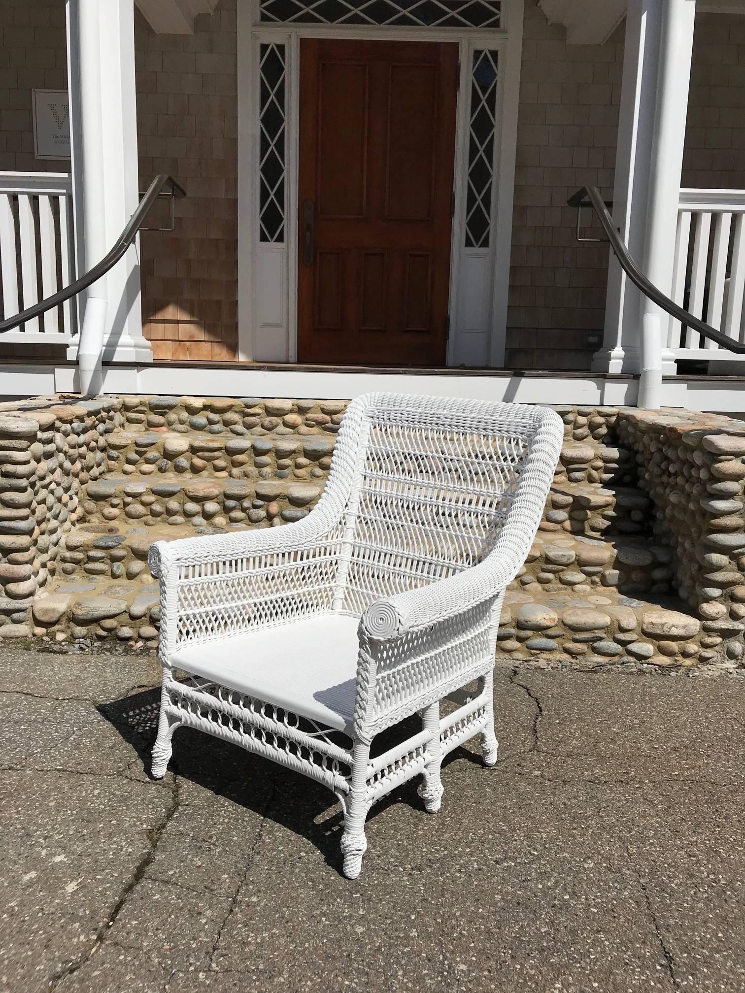 Large-scale Victorian six-legged chair in fresh white paint. Rolled arms and back, wrapped feet and pressed cane seat add to the charm of this hand-woven piece. Chair measures 36 inches tall, 28 inches wide, 31 inches deep and has a seat height of