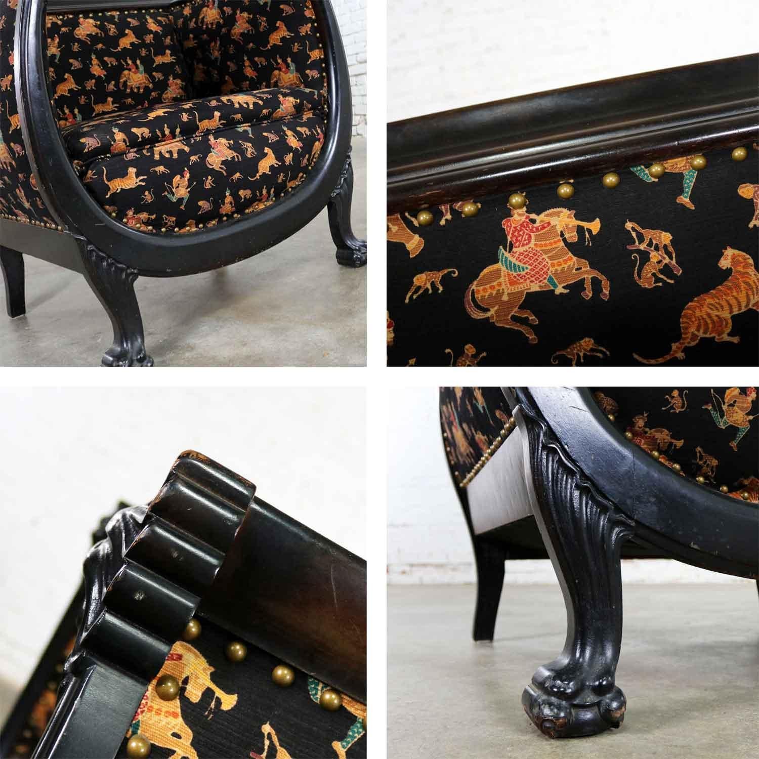 Handsome Victorian hand carved wishbone barrel chair with lion’s heads and lion’s claw feet. It has been ebonized and recently reupholstered with a black gaberdine like fabric. It is in wonderful condition with nice wear spots on the blackened wood,