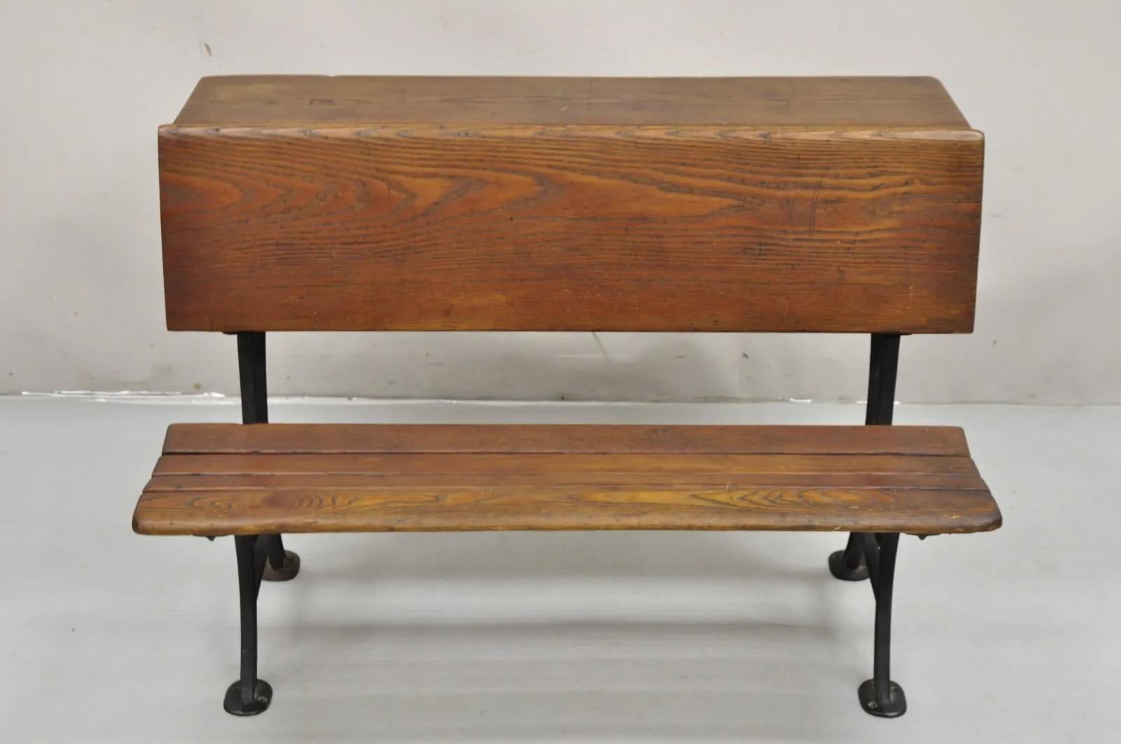 Antique Victorian Wood & Cast Iron Children's School Desk w/ Folding Bench Seat. Item features cast iron supports, folding seat, solid wood construction, rear facing cubby entry, very nice antique school desk. Circa 1800s. Measurements: 25.5