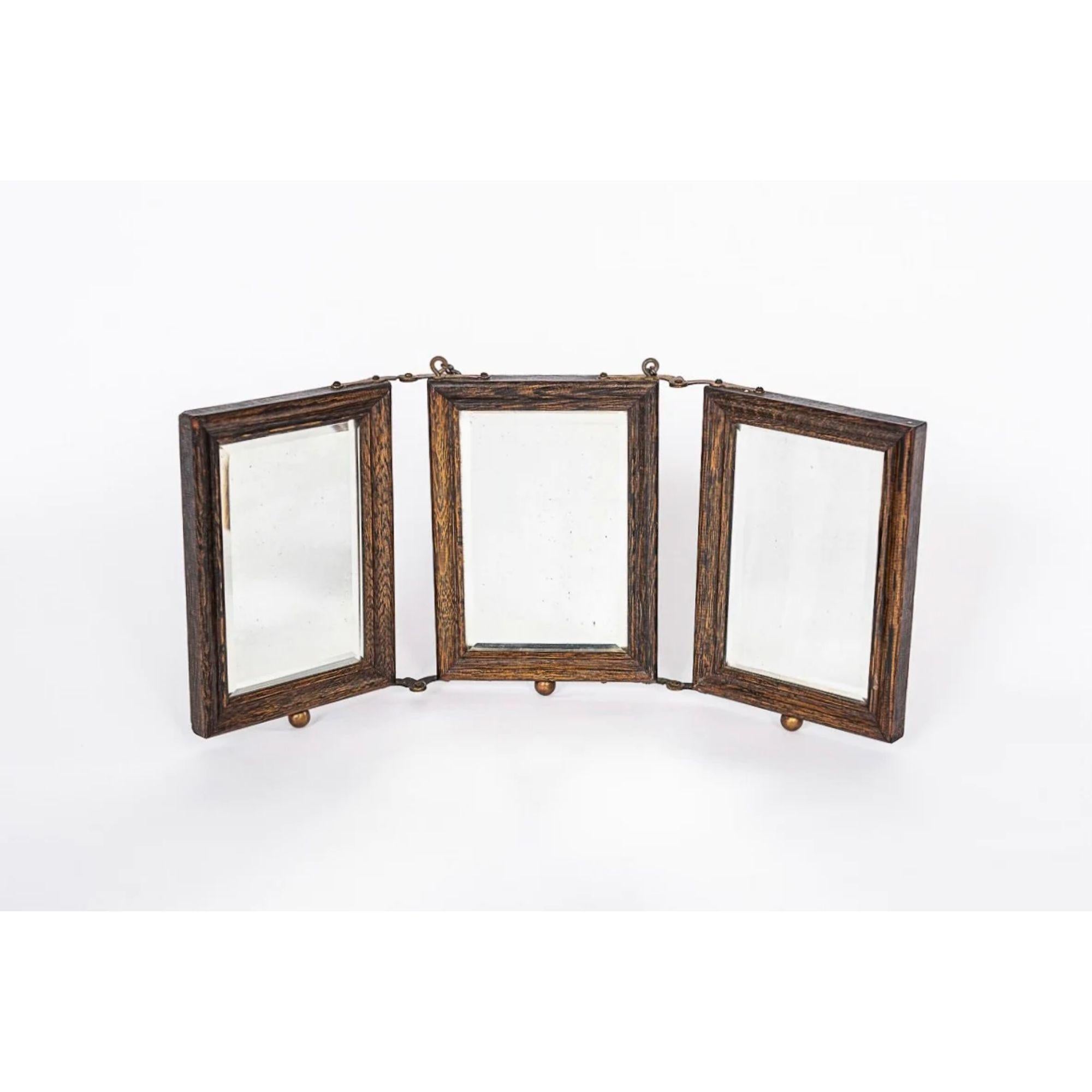 This exceptional antique Victorian barber’s shaving or travel mirror circa 1910 has three beveled mirrors set in a beautiful oak wood frame with embossed industrial brass embellishments and riveted hinges. These versatile travel mirrors were