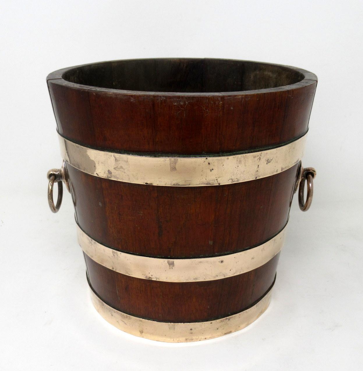 An exceptionally fine quality coopered teak and brass bound circular flower tub, jardinière or wine - champagne bucket holder made by London Cooperage H M Champion & Co.

Third quarter of the 19th century 

The main polished Teak frame bound