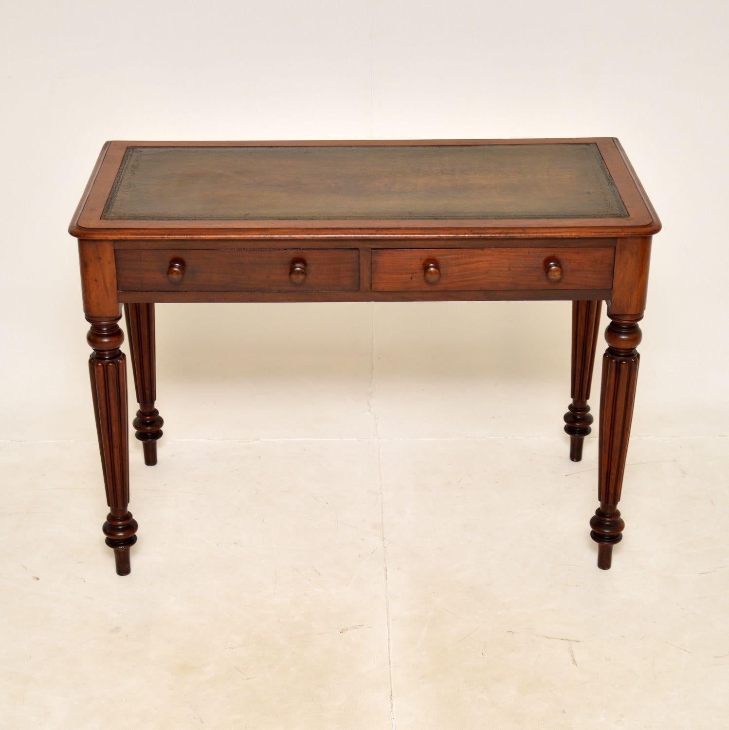 A smart and useful antique early Victorian writing table / desk. This was made in England, it dates from the 1840-1860s.

It sits on beautifully turned and fluted legs, with a hand coloured tooled leather writing surface. The drawers have nicely