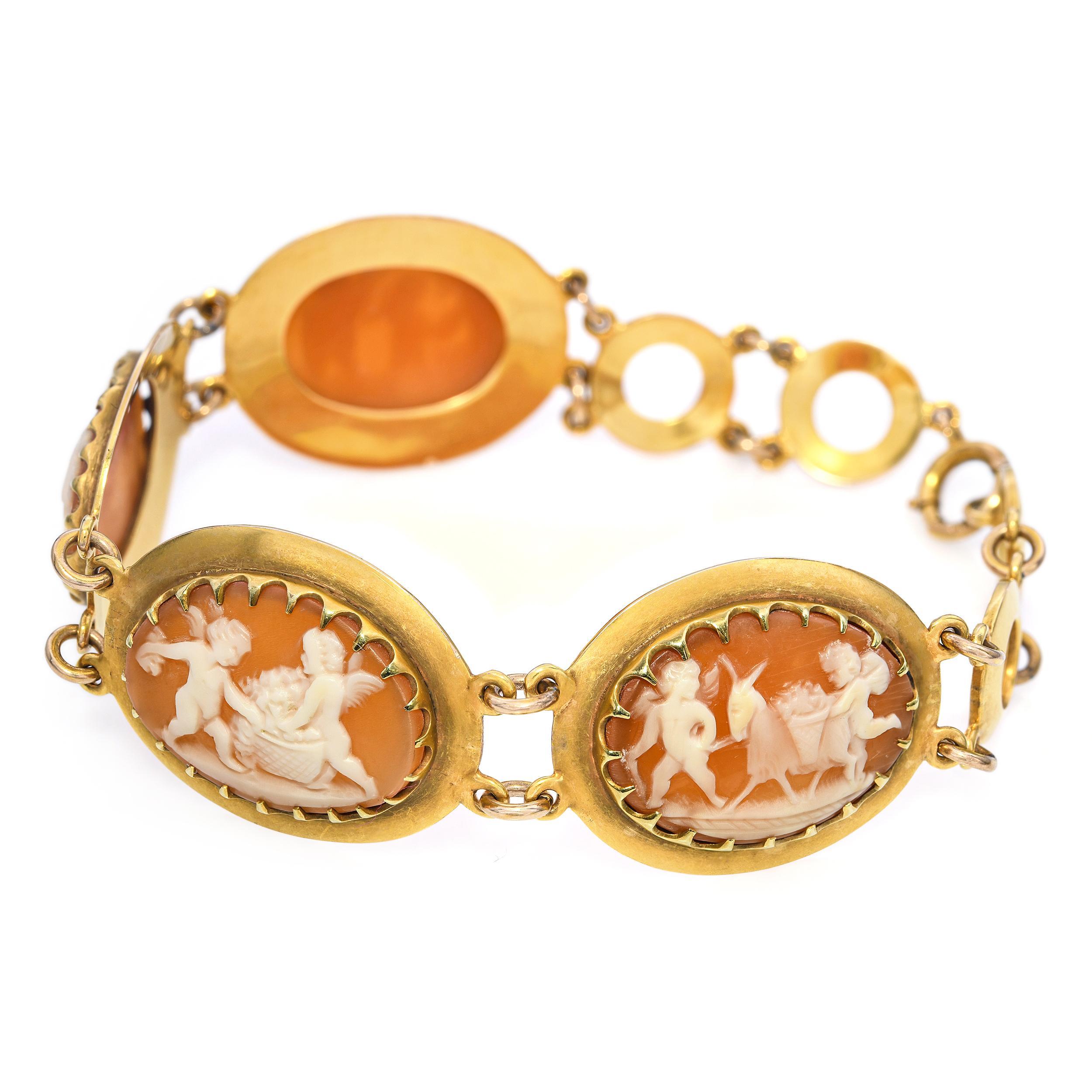 Beautiful antique 13k yellow gold bracelet featuring four finely carved shell cameo panels, each depicting lively cherub and mythological scenes in high relief. The warm orange-brown shell contrasts elegantly with the soft matte gold frames, giving