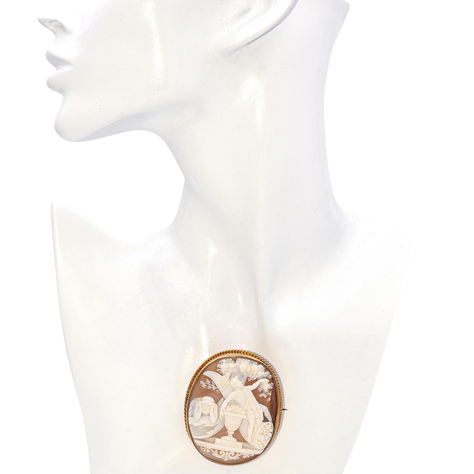 Este broche camafeo victoriano presenta una escena bellamente tallada que representa a dos figuras icónicas de la mitología griega: Dioniso, el dios del vino y la juerga, y Cronos, el antiguo Titán. En la escena, Dioniso aparece cómodamente
