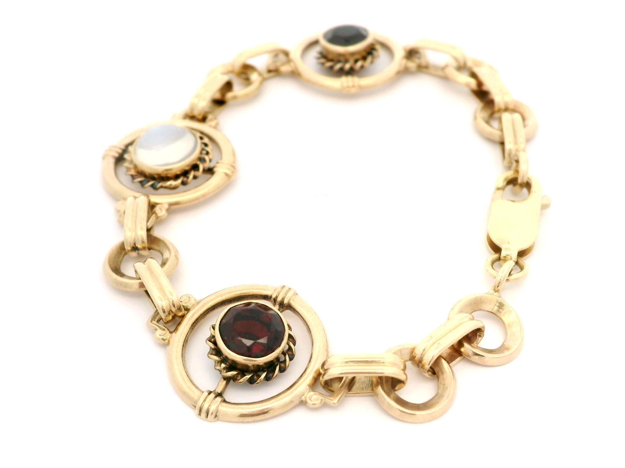 --Pierre(s) :...
(2) Grenats véritables naturels - taille ronde ancienne - sertis - couleur rouge foncé - 5,8 mm (approx. chacun)
(1) Pierre de lune véritable naturelle - taille cabochon rond - serti - couleur bleue - 6,6 mm (approx.)

MATERIAL : Or