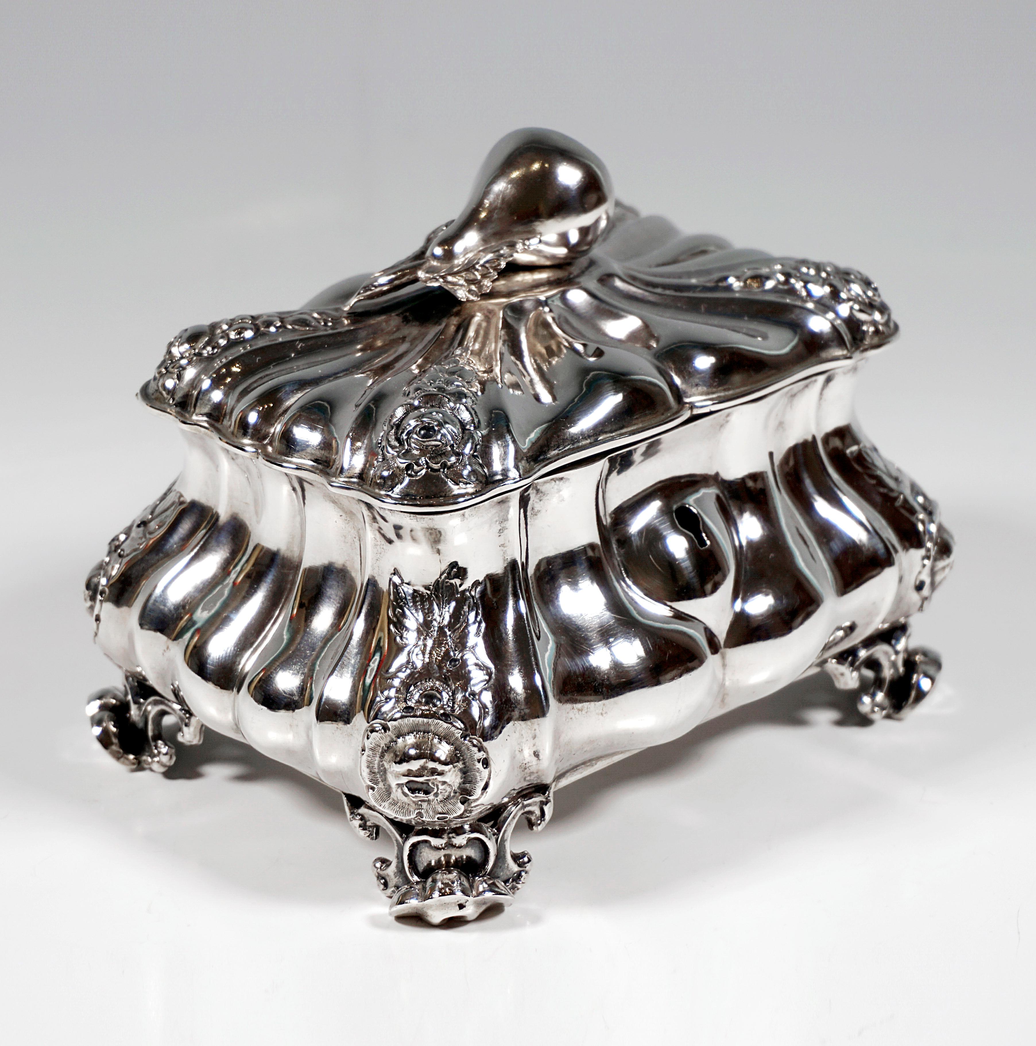 Biedermeier silver sugar bowl in rectangular basic form on four rocaille feet, the walls of the container drawn in towards the top and provided with folds, which run straight on the narrow sides and curved on the wide sides, floral decoration in