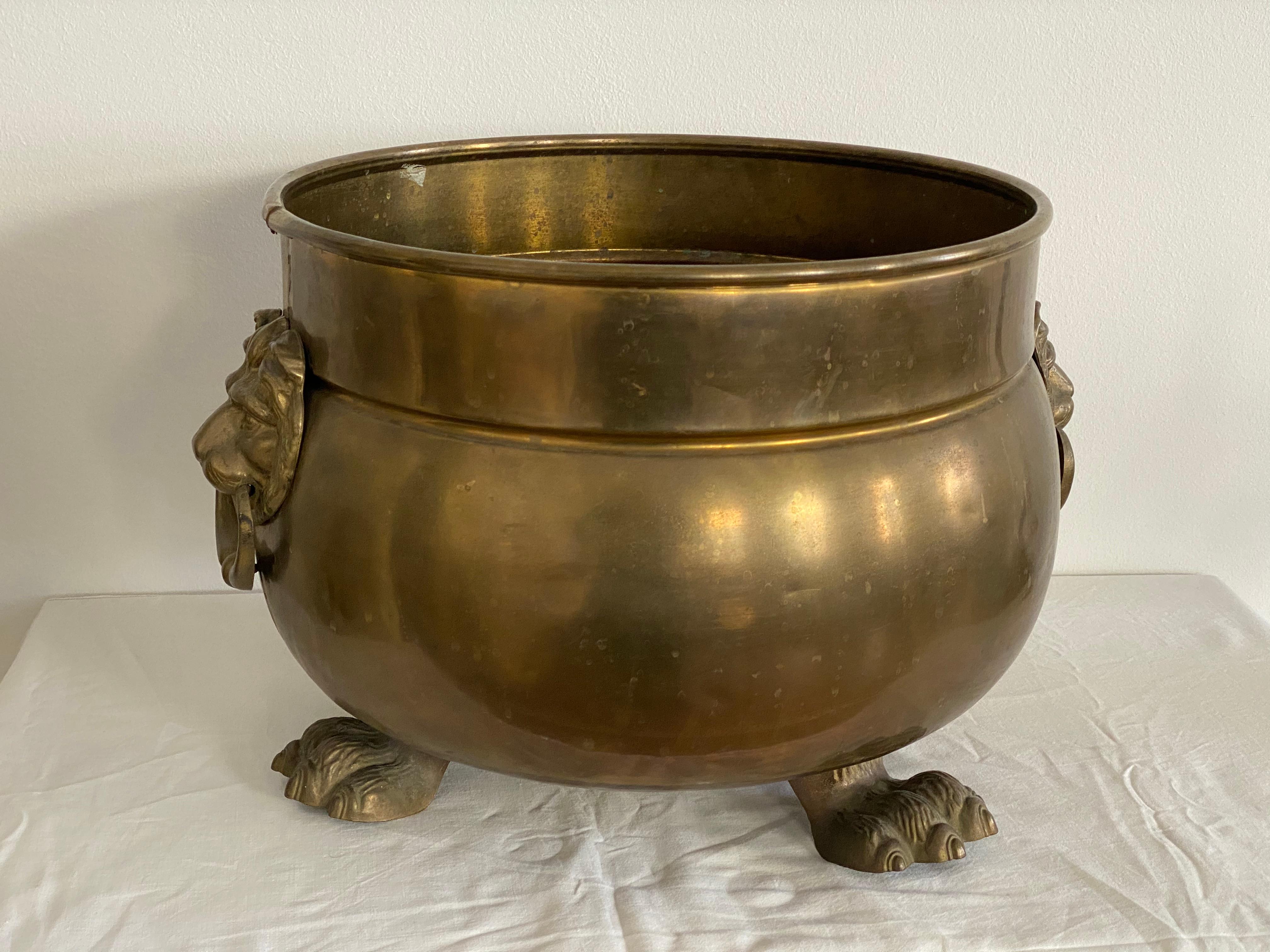 Rounded copper planter features 3 brass feet and 2 brass lions heads with rings on
each end. Made in Austria in the early 1950s.