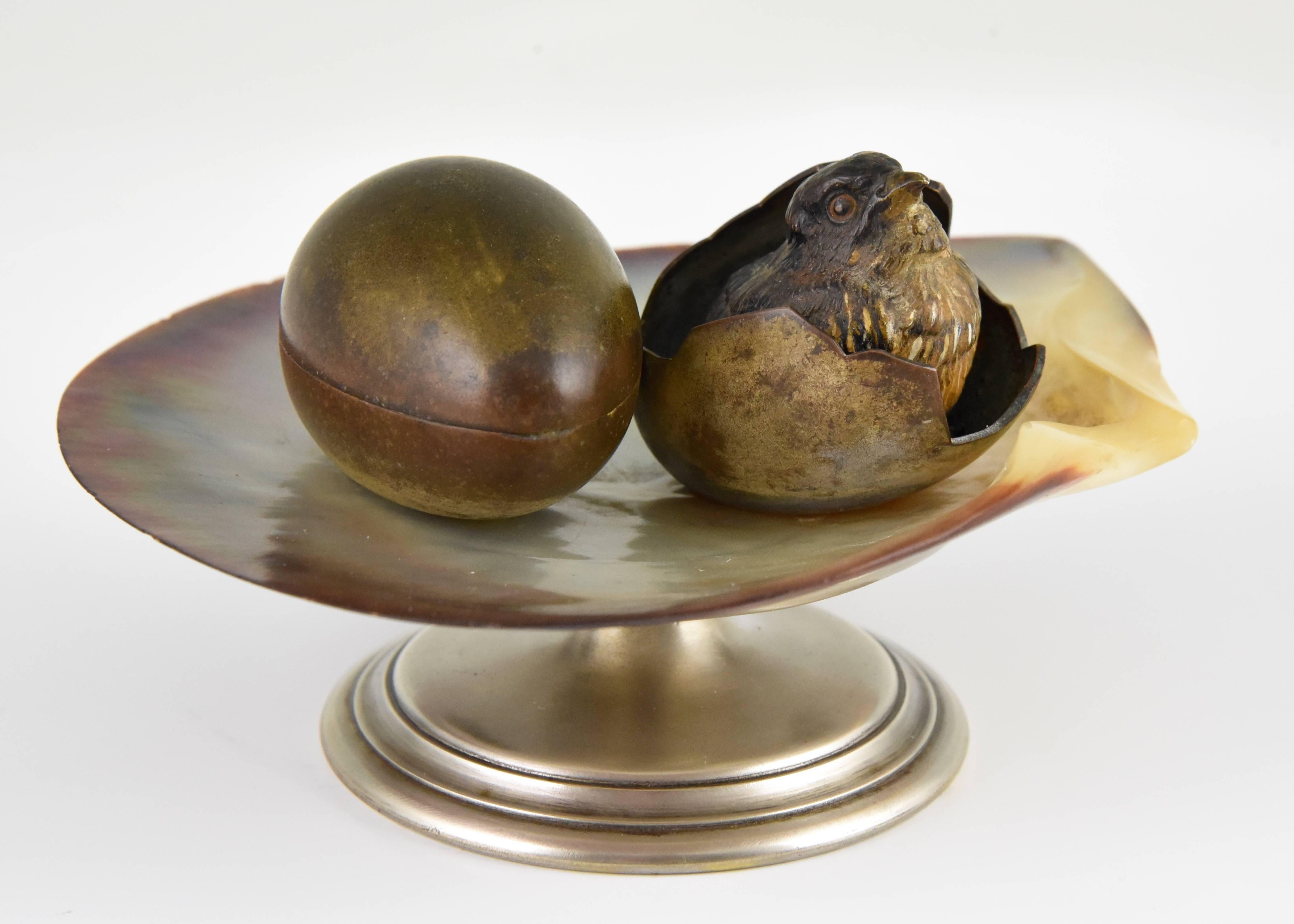 Lovely cold painted Vienna bronze inkwell tray of natural sea shell with young bird in egg shell. The other egg can be opened.
Marked: Geschutzt.
Date: 1900.
Material: Cold painted and silvered bronze, natural seashell.
Origin: Vienna,
