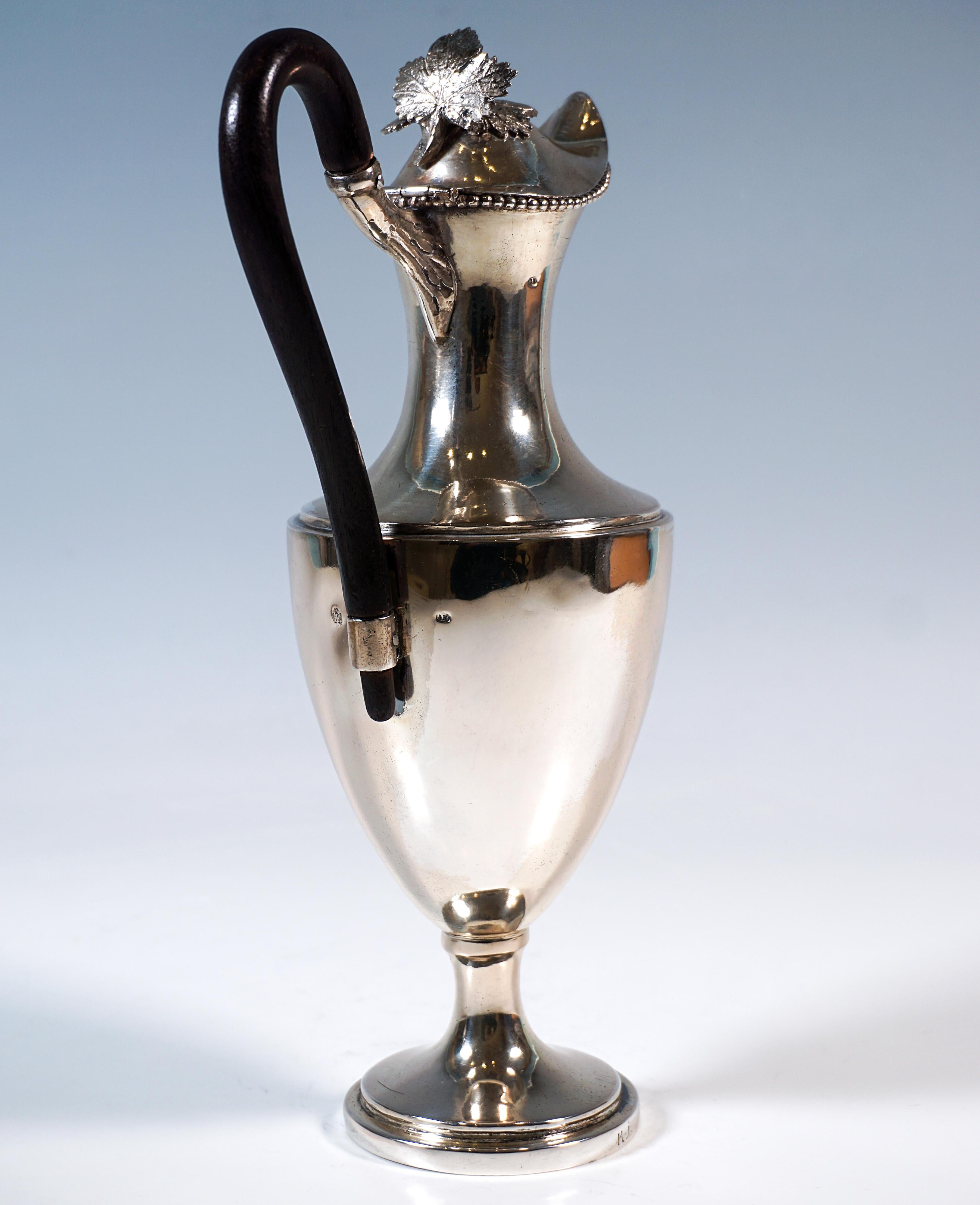 Pichet à couvercle en argent à finition lisse sur une base ronde en forme d'entonnoir avec un bord profilé, un léger nodule au-dessus de la constriction, un corps surélevé en forme d'œuf avec une constriction de col en retrait et un bec généreux