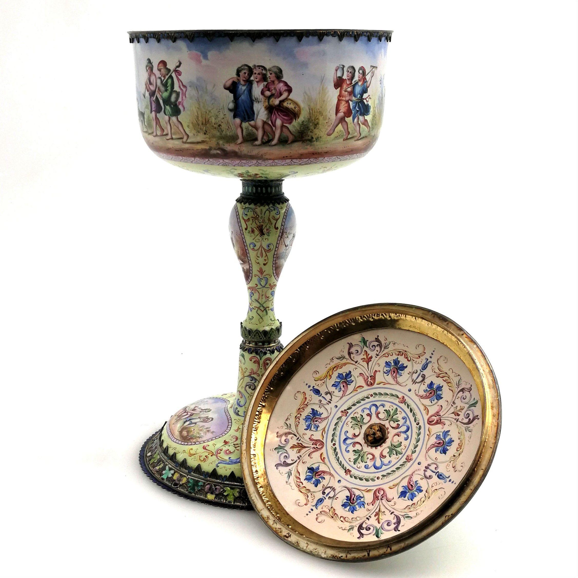 A magnificent Antique Silver and Viennese Enamel standing Cup and Cover. This impressive Cup has a straight sided body supported by a shaped column on a wide spread foot. The Cup has a fitted lid with a figural finial. The entire exterior and