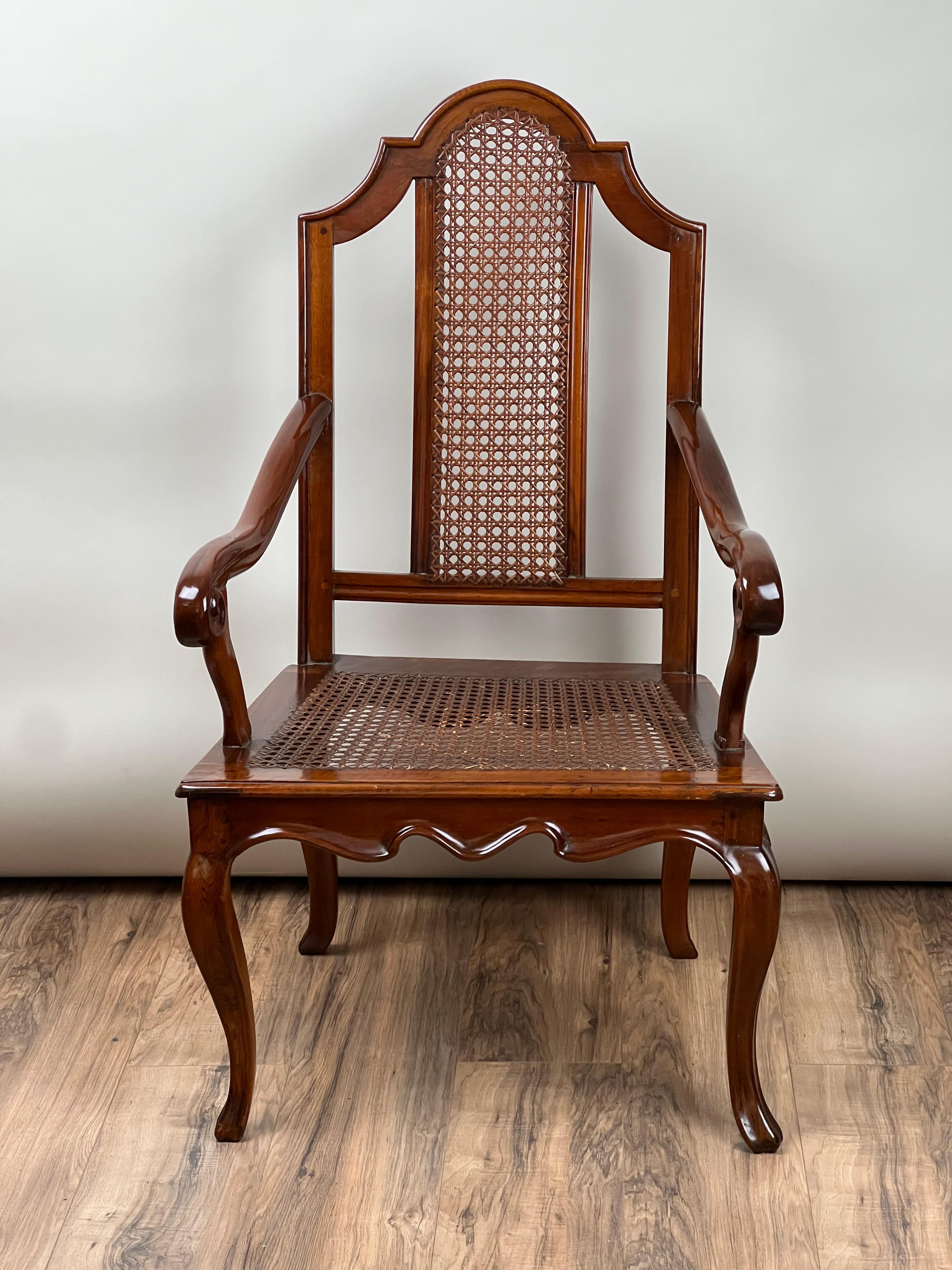 Questa antica sedia a bracci in noce viennese con seduta a canne, risalente alla fine del XIX secolo, emana un'eleganza senza tempo grazie al suo design raffinato e alla sua lavorazione artigianale. Realizzata in noce scuro, la sedia è