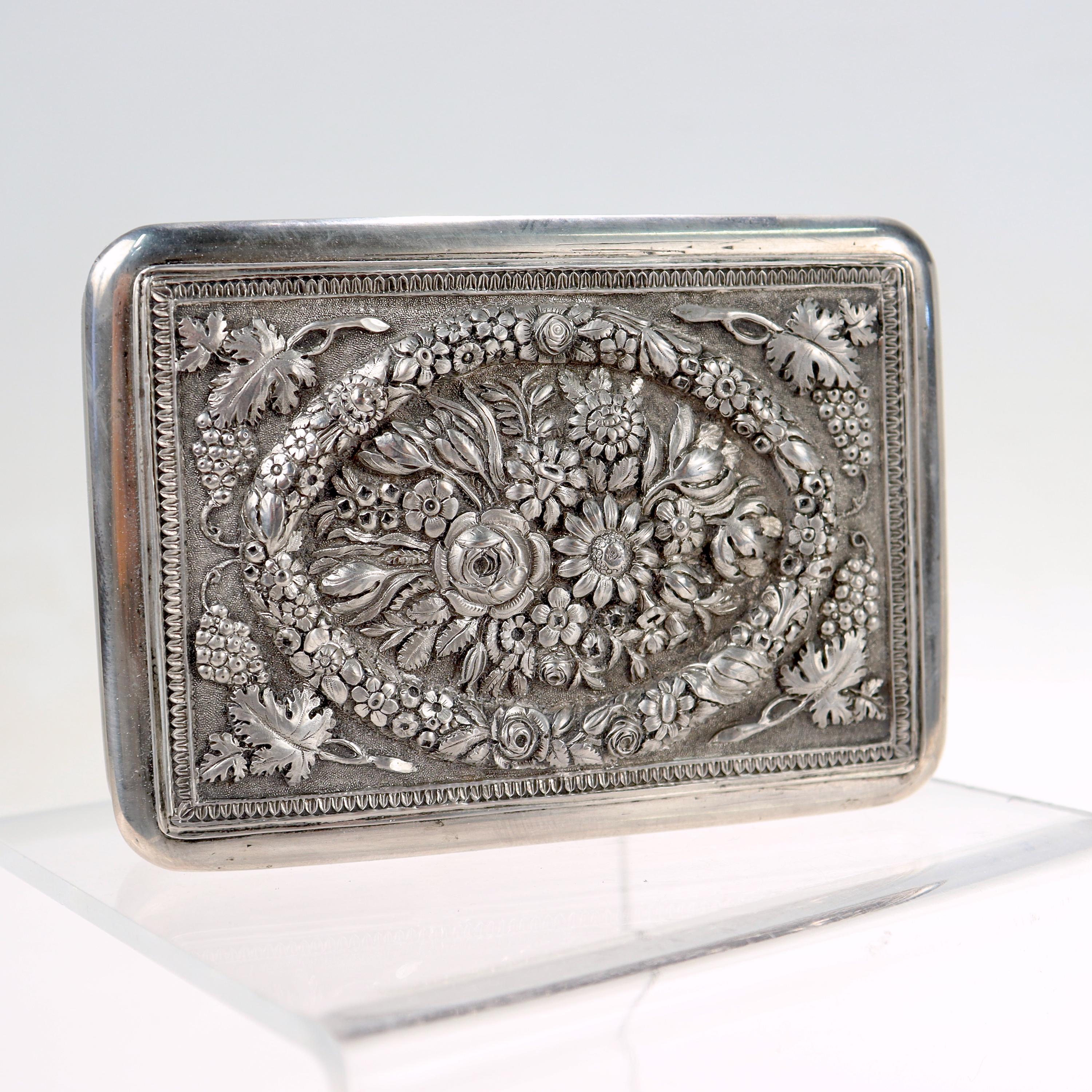 A fine antique silver card case or snuff box.

With repousse floral motifs to the lid and a gold washed interior. 

There is an Austrian silver assay mark for 13 Loth, Vienna, and 18_7 (1807-1857), along with a maker's mark 'GS'. 

Simply a lovely