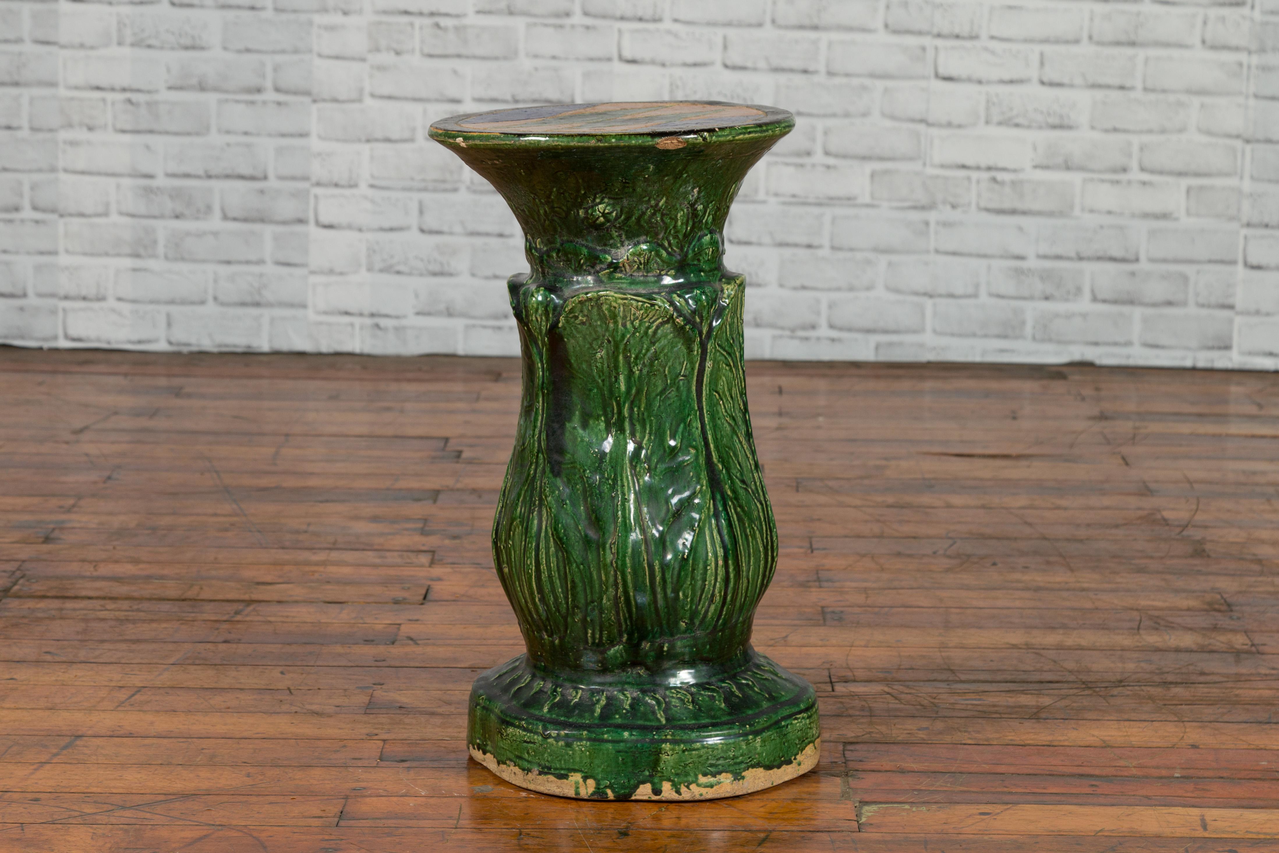 An antique Vietnamese green glazed pedestal from the early 20th century, with foliage design and diamond patterns. Created in Vietnam in the early years of the 20th century, this green glazed pedestal features a circular top adorned with blue and