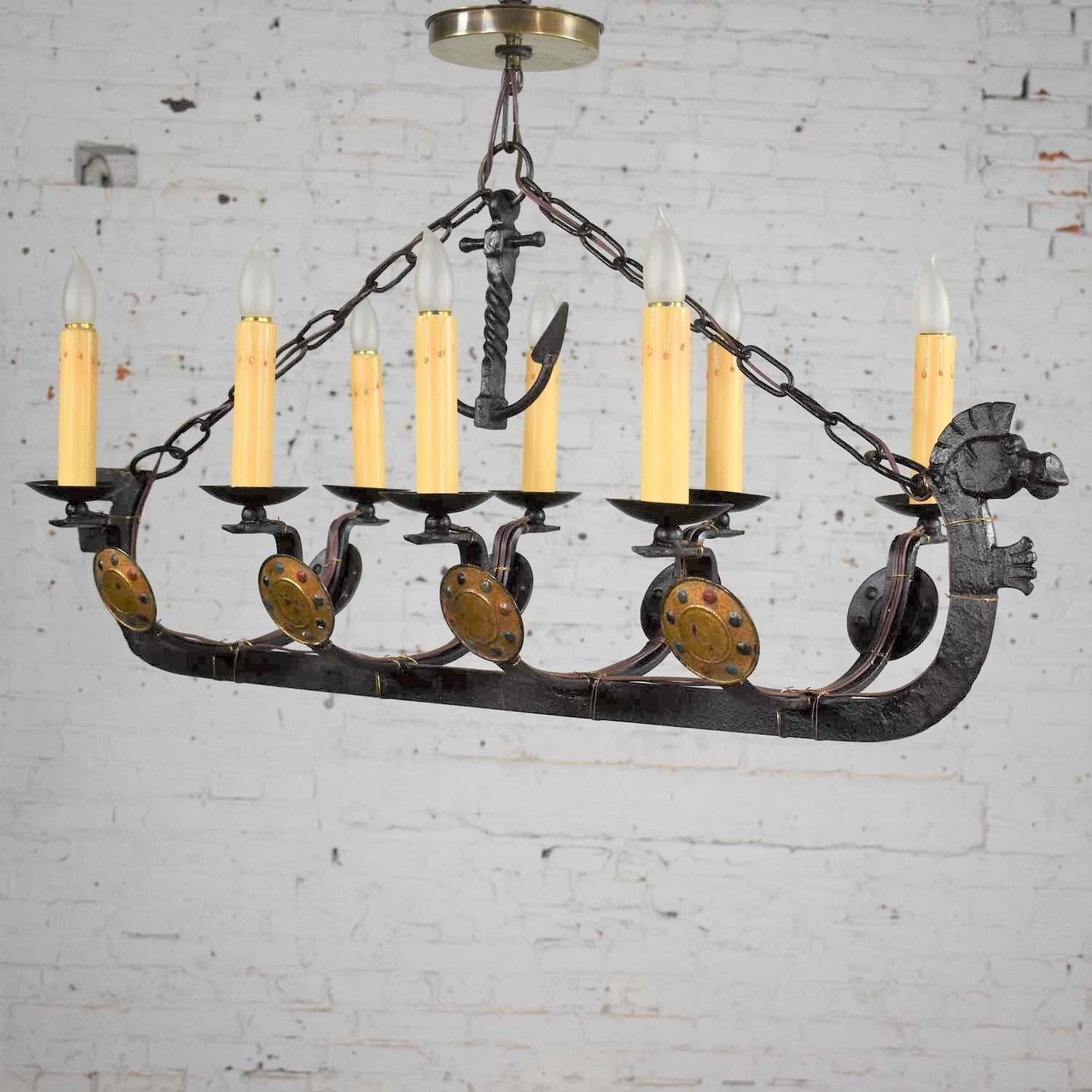 Handsome and unusual cast iron eight light chandelier in the shape of a Viking longboat or ship with a horse head, horse tail, warrior shields, chain and anchor details. It is in wonderful antique condition. The cast iron has a natural patina that