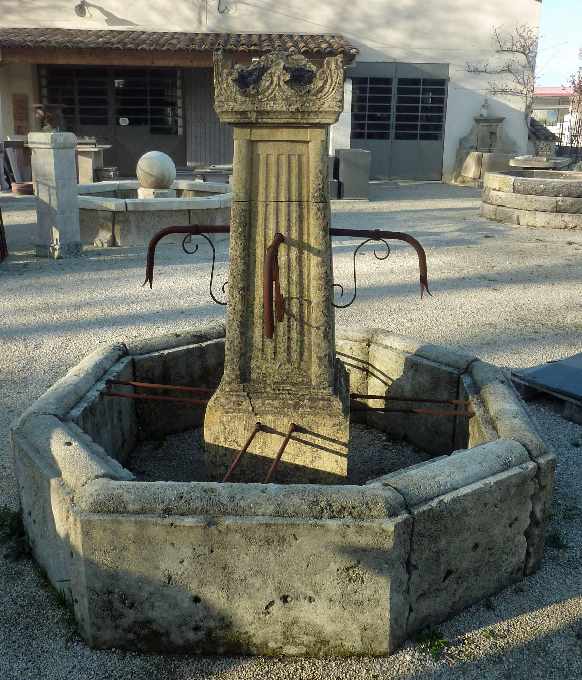 This elegant antique fountain is composed of a central post sculpted with finger-fluted moldings and adorned with four metal water spouts with forged volutes. This post is topped by a stunning finely hand-sculpted cornice.
The basin has an