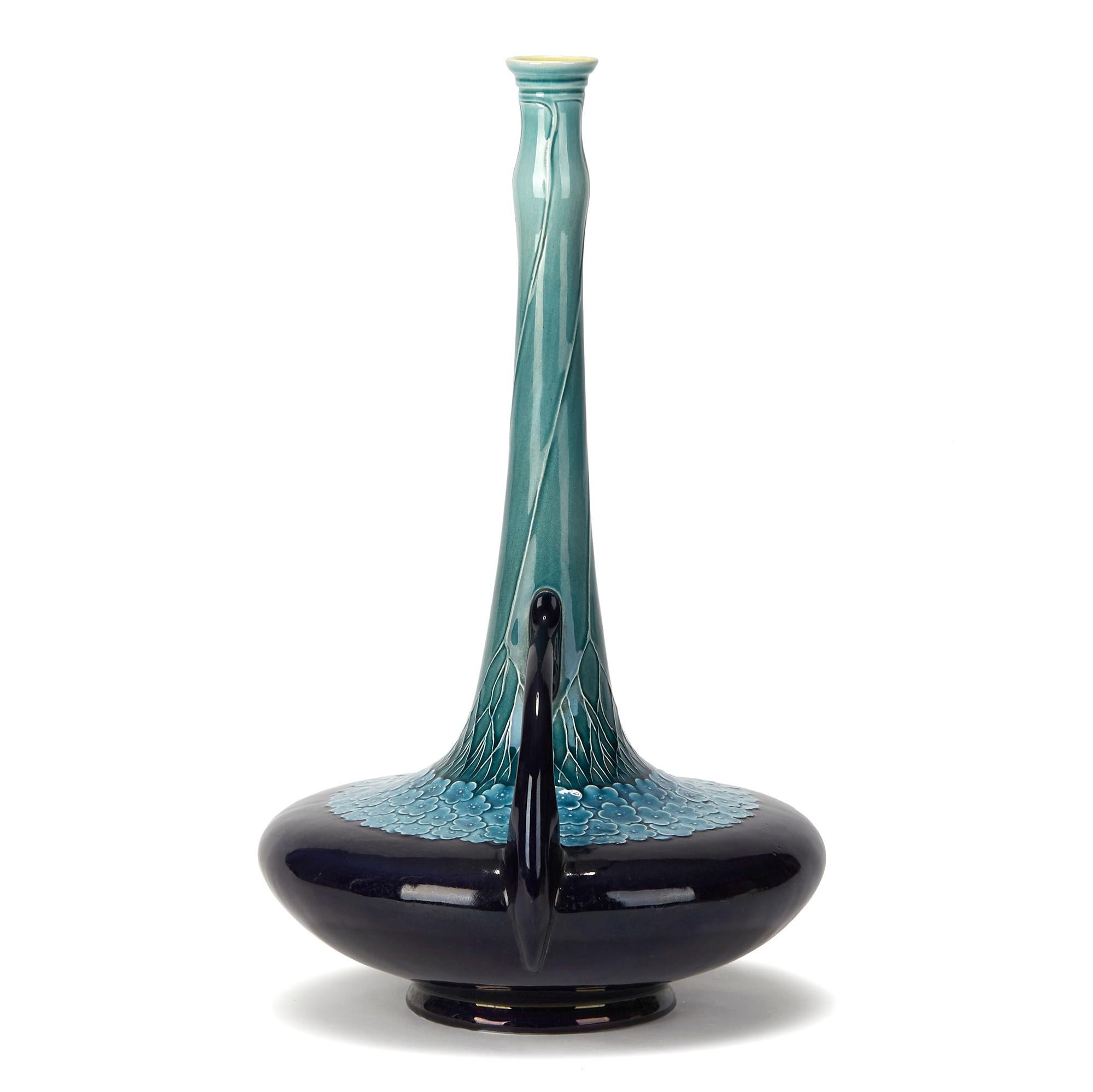 A stunning and elegant Art Nouveau Villeroy & Boch Mettlach twin handled art pottery vase of bottle shape with a squat wide rounded body standing on a narrow rounded foot with a tall slender neck with loop handles applied to either side of the body.