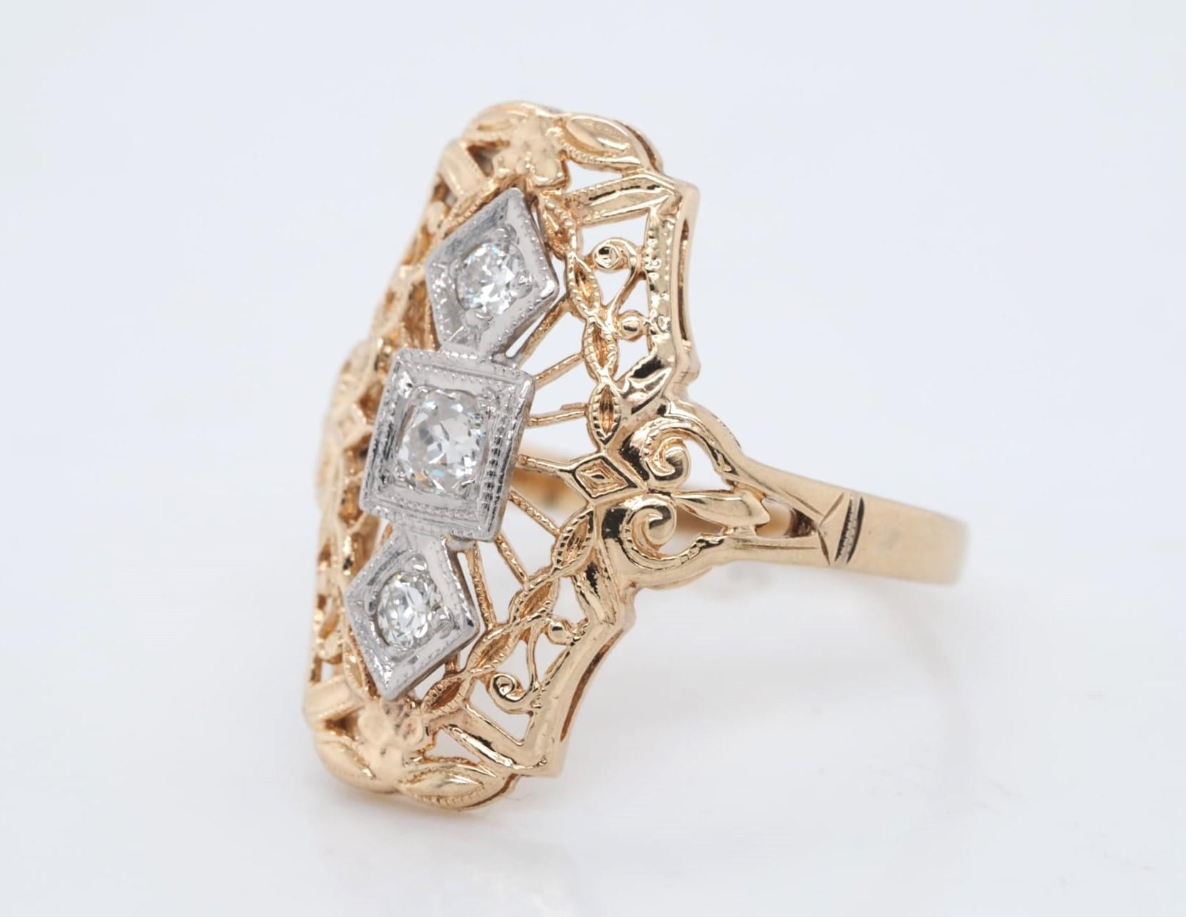 This stunning antique ring is crafted from 14k yellow gold and palladium, featuring a natural round Old European cut diamond with a total carat weight of 0.23. The diamond has a clarity grade of SI1-SI2 and a color grade of H, and is set in a prong