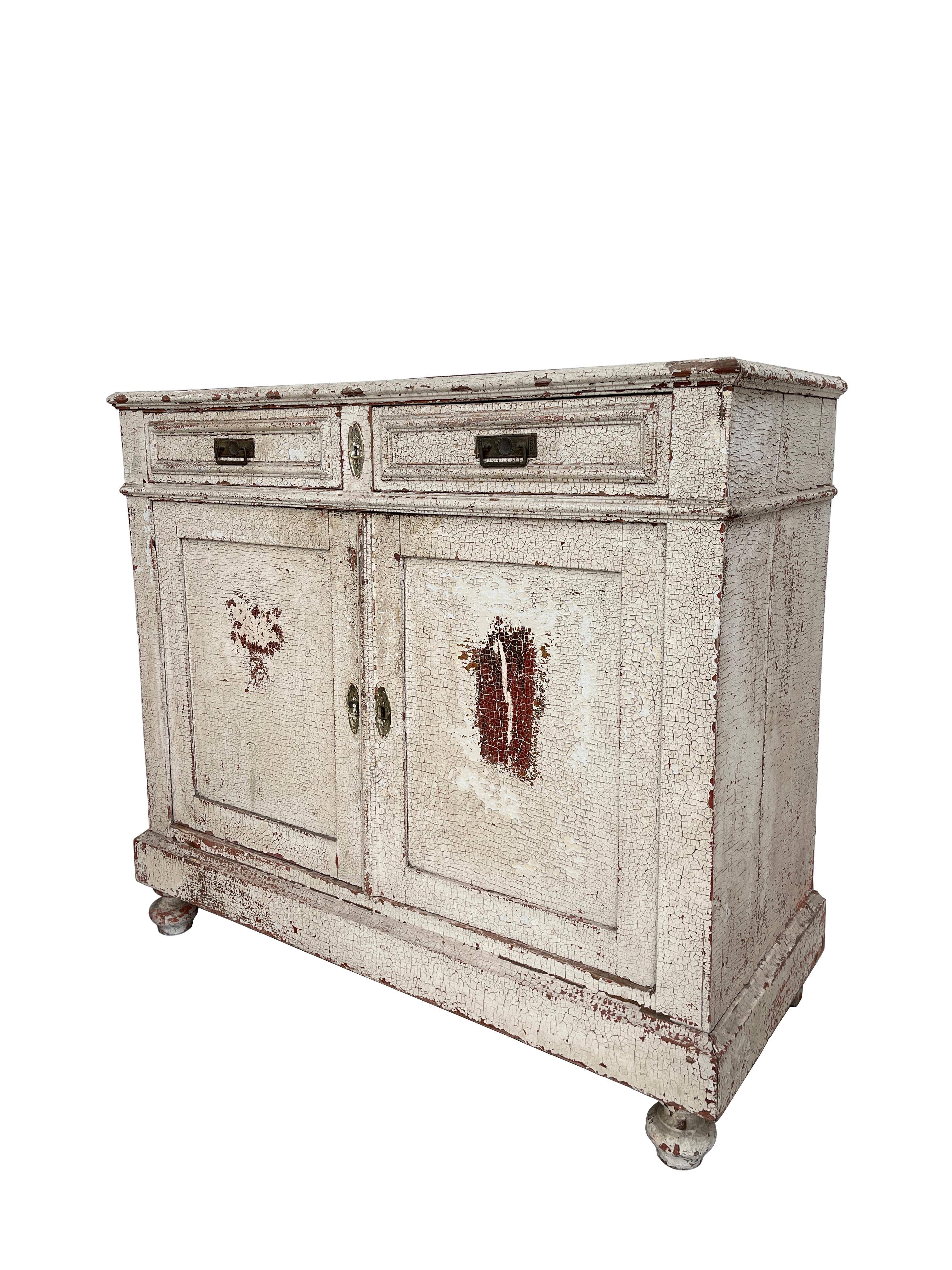 - A beautiful 19th century French painted credenza cabinet. 
- The cabinet has been repainted over the course of its life which has resulted in the most original incredible age worn finish. 
- Raised on scrolling legs the cabinet features two