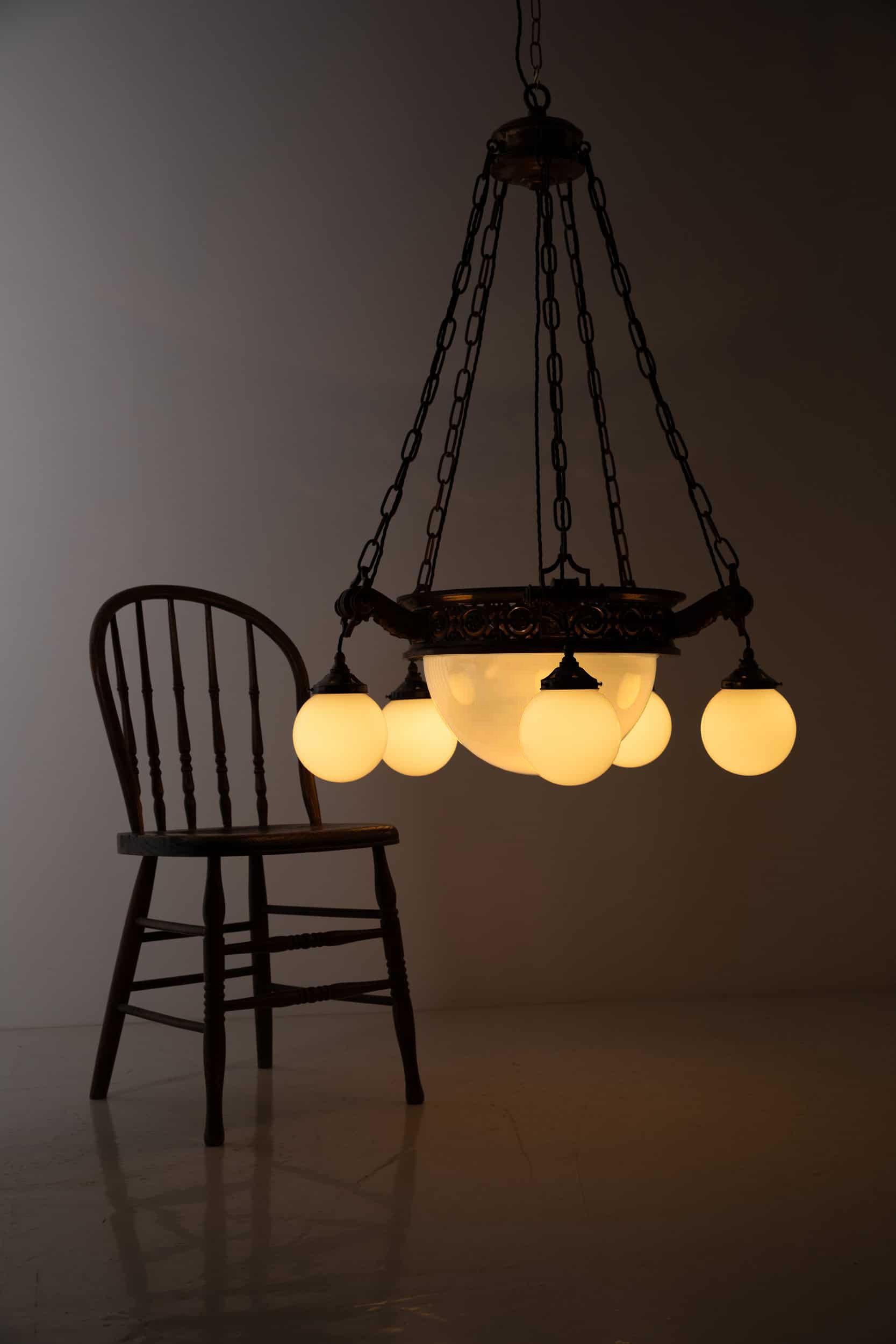 A huge and imposing 5-arm cast brass and opaline chandelier. c.1920

Of very high quality, comprising of heavy duty cast brass decorative ring, chain and hanger. Completed with central opaline bowl and five perimeter opaline globes.

An incredible