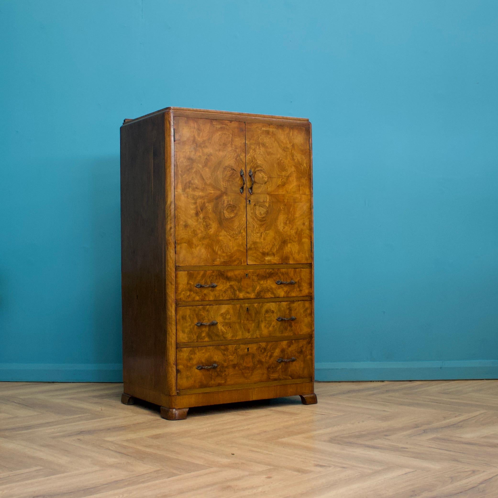 An Art Deco walnut tallboy or linen cabinet, circa 1930's
Featuring a cupboard with two shelves and three drawers, with solid brass handles
The burr walnut veneers are in beautiful original condition

There is no key but the door remains shut once