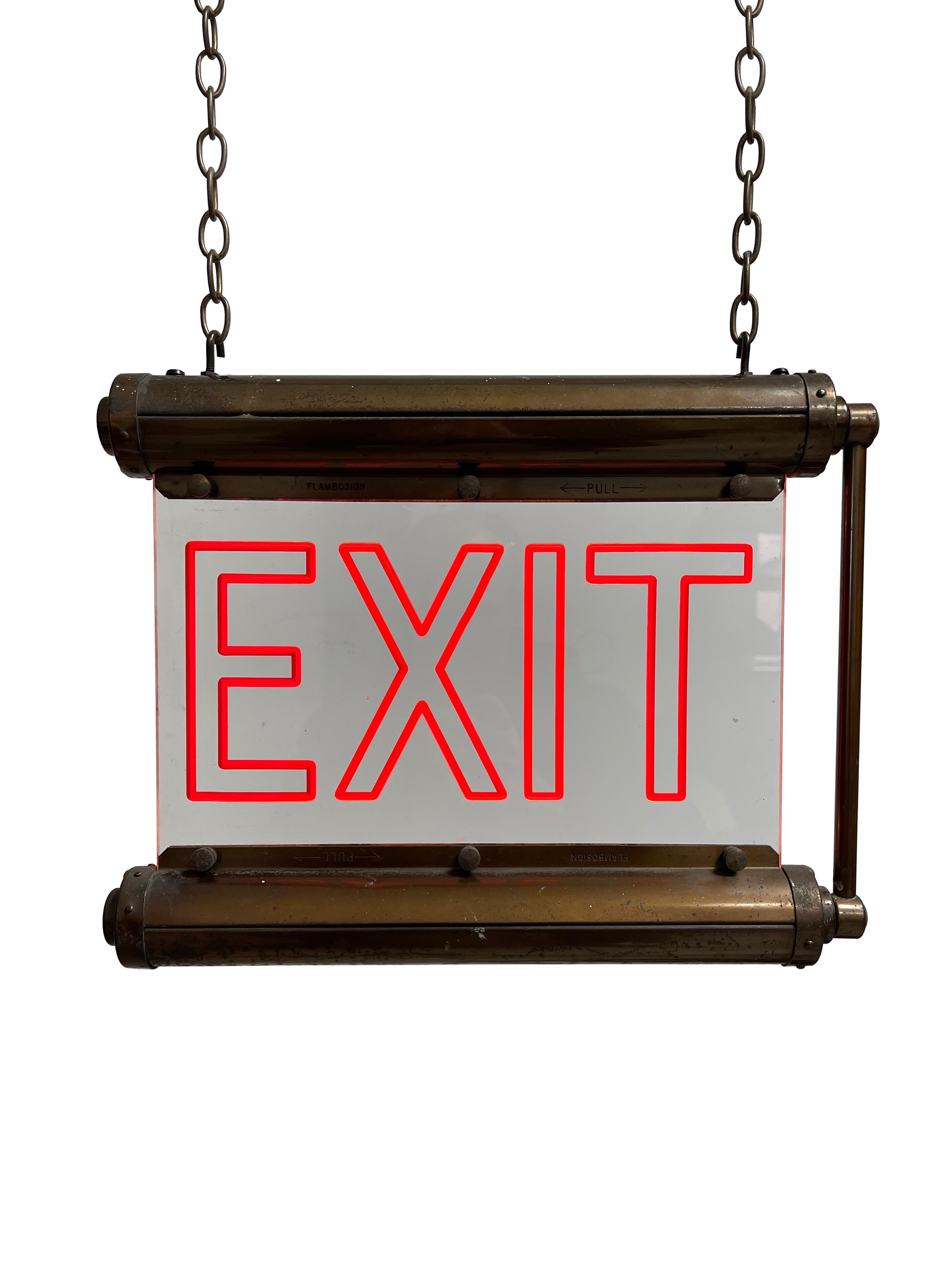 - A fabulous Art Deco illuminated exit sign from renowned manufacturers 'Flambosign', Early Twentieth Century.
- The brass casing marked 'Flambosign' to both the top and bottom section houses an etched lucite perspex sign which glows red when