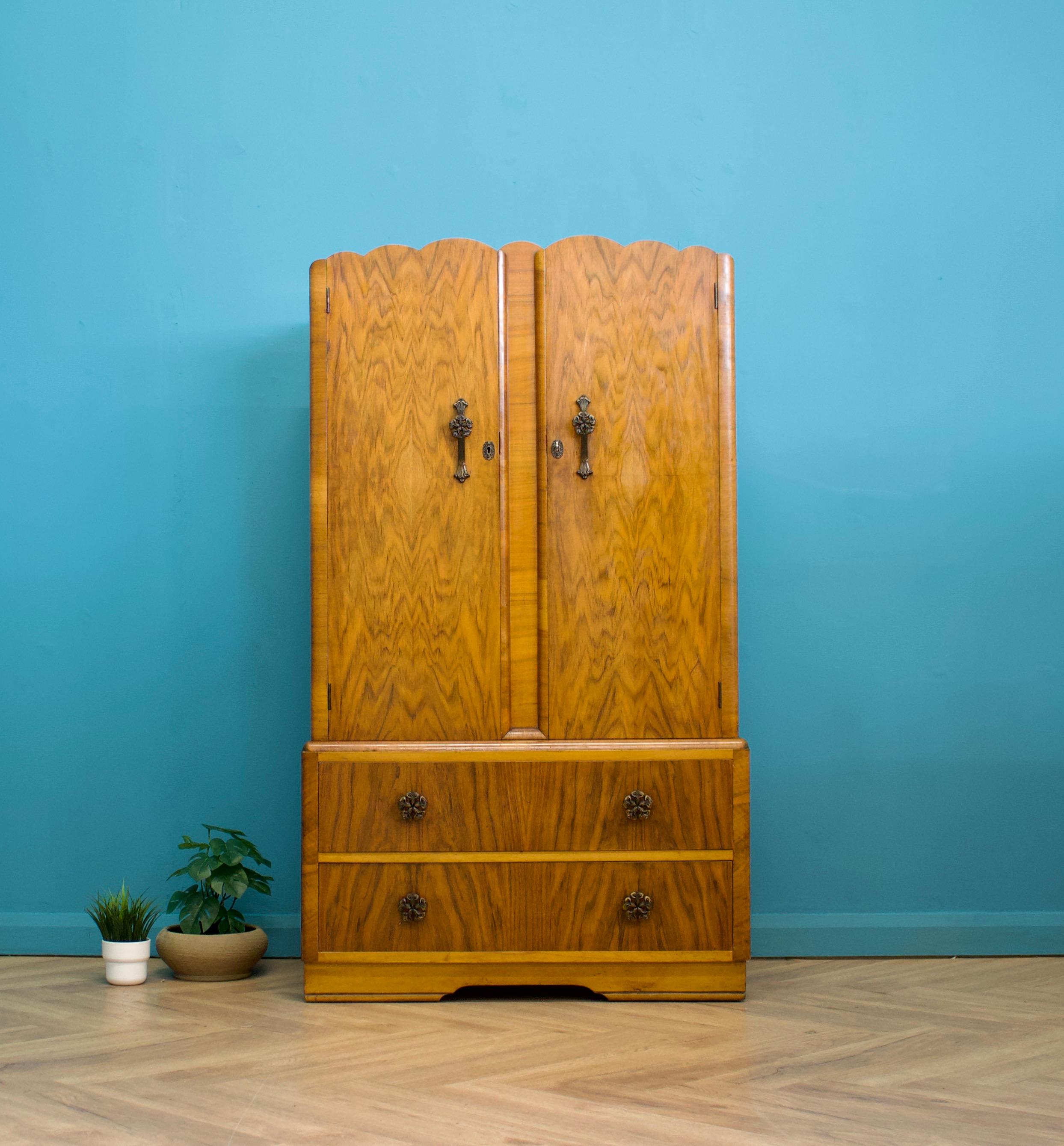 A vintage walnut Art Deco compactum / compact wardrobe
Inside is fitted out with a rail and there are two drawers to the bottom
It also features decorative metal handles