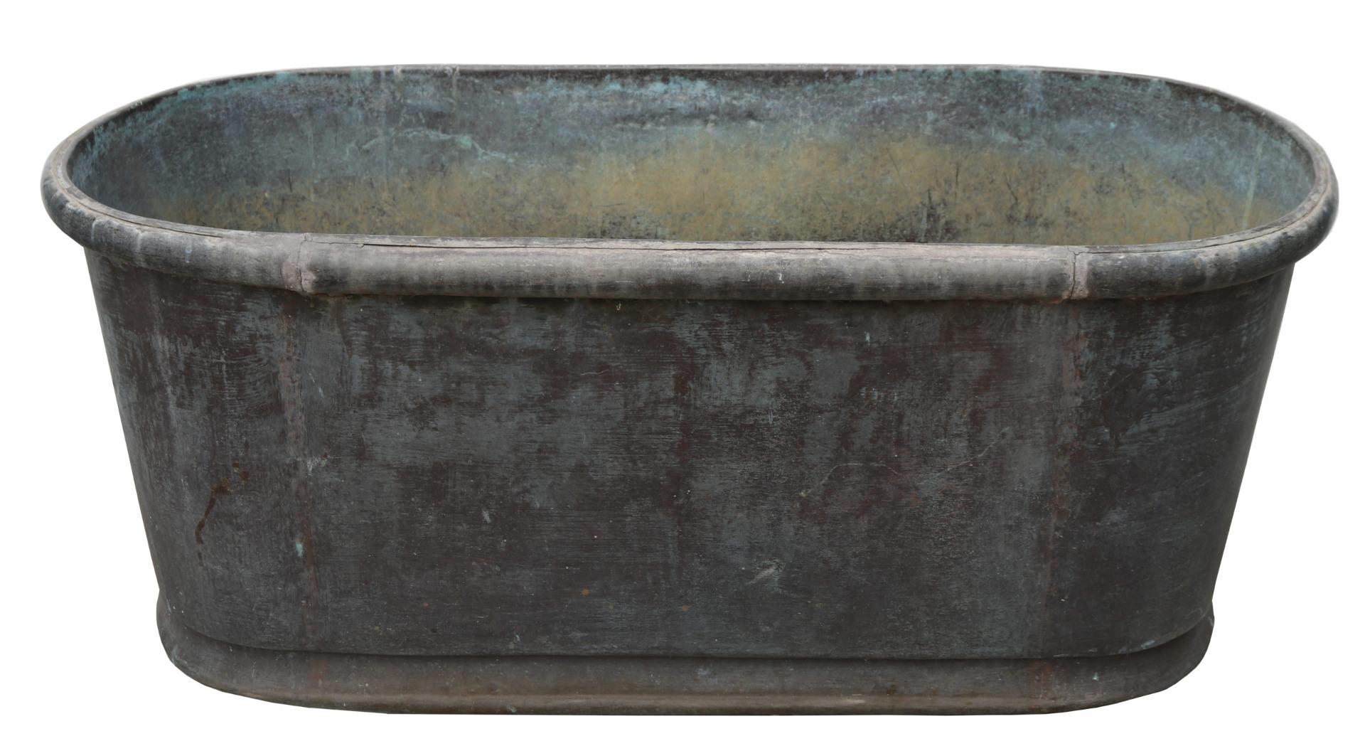 A reclaimed copper bathtub with a weathered verdigris finish and rolled top.