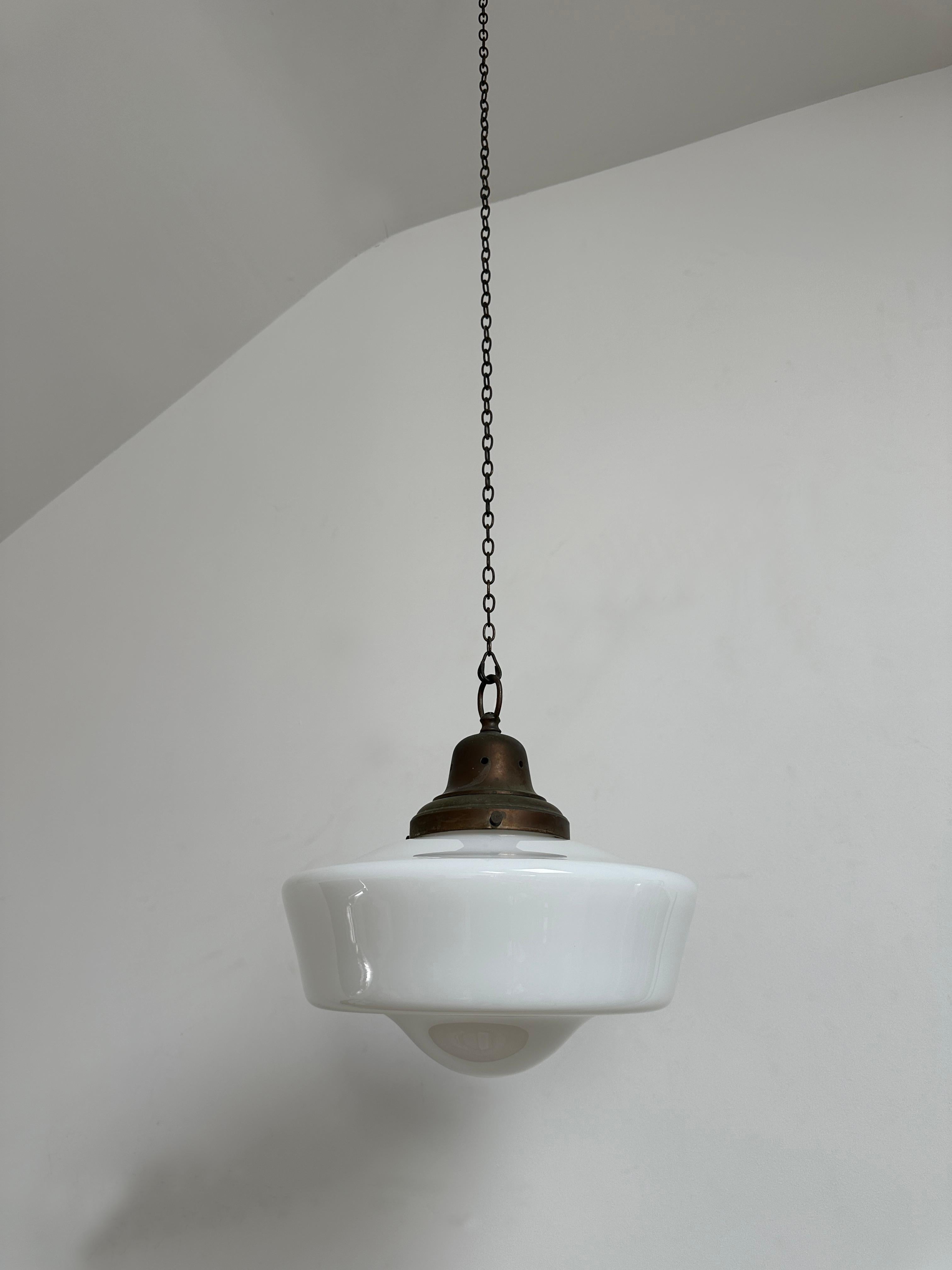 - Colgante de techo opalino con galería original, Inglaterra, hacia 1930.
- Forma poco habitual de la pantalla de cristal, galería pesada con acabado en bronce envejecido.
- Recableado con flexo trenzado marrón y prueba PAT.
- Altura 36 cm, Anchura