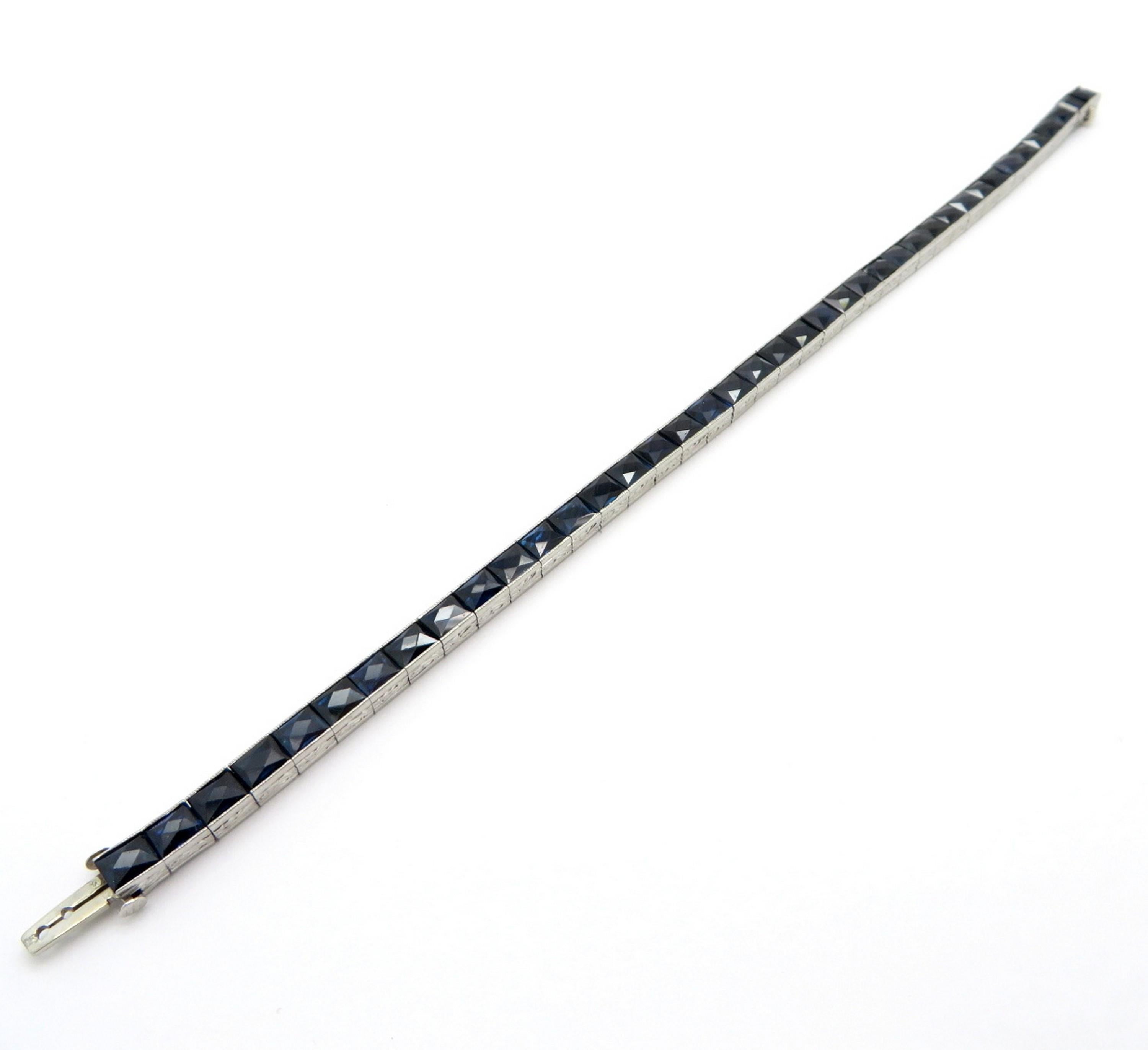 Antique Art Deco style French cut sapphire tennis bracelet. Showcasing 40 antique square French cut sapphires channel set in a row. The bracelet measures 7.25” inches long and 4.40 mm wide. The sides of the setting feature hand engraved detailing.