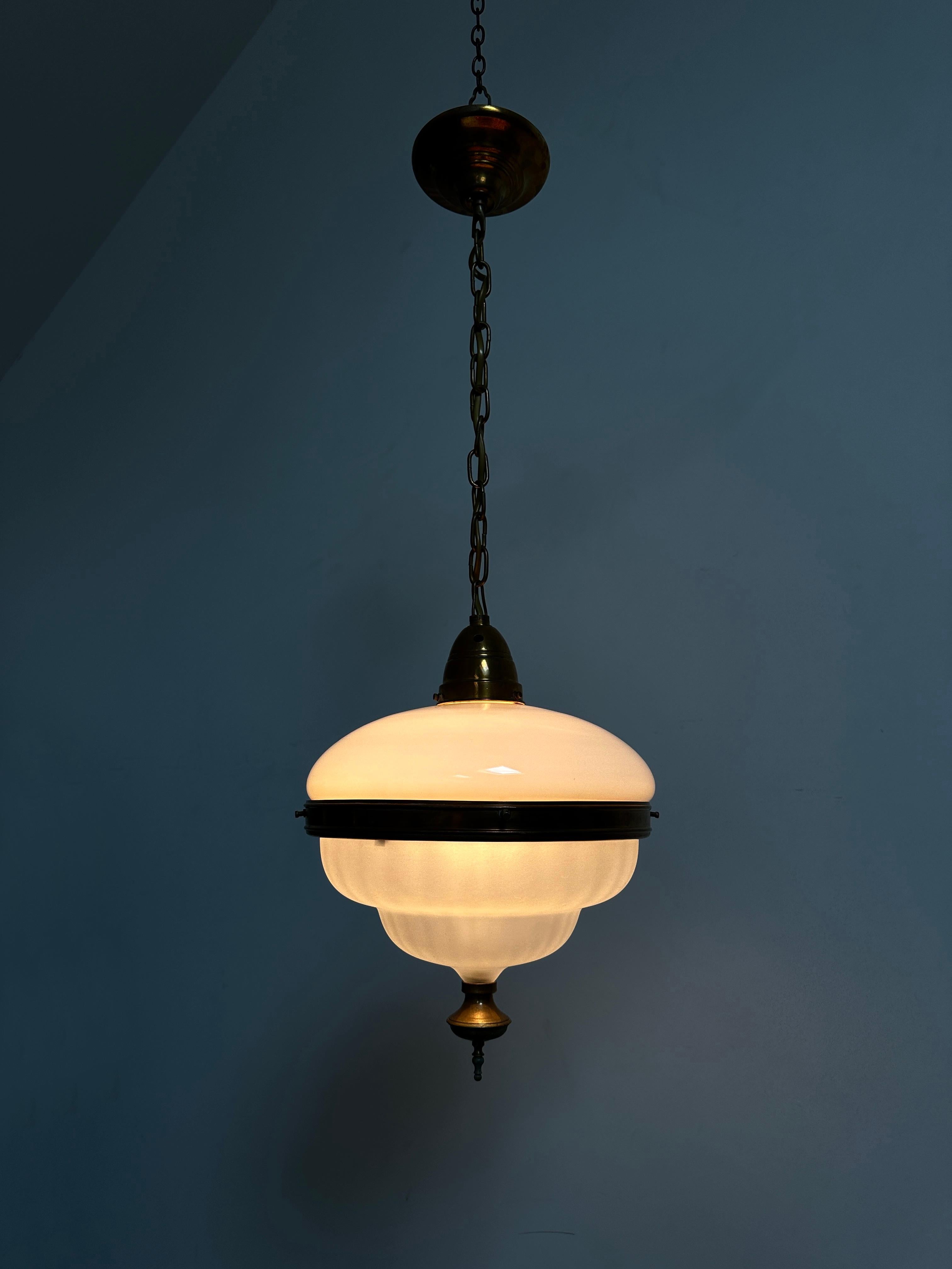 - An original and rare Bauhaus opaline brass ceiling pendant, Germany circa 1930.
- The pendant consists of an opaline shaped body and lower dish, held together by a decorative brass band. 
- Beautiful unusual design and of great quality, in an