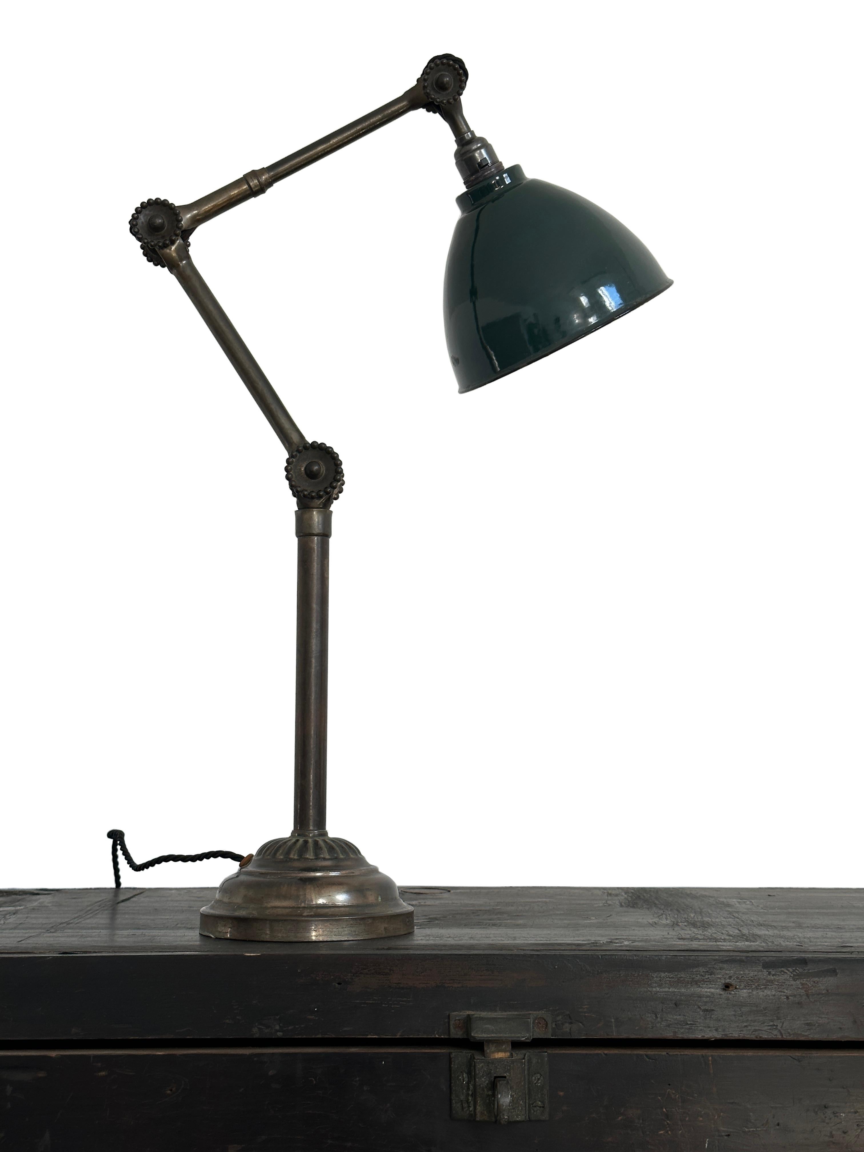 - A rare and early example of a brass daisy joint table lamp by the illustrious John Dugdill, circa 1920.
- This scarce lamp features the trademark 'daisy head’ joints in three places for tightening the arm and head, an aged worn original deep