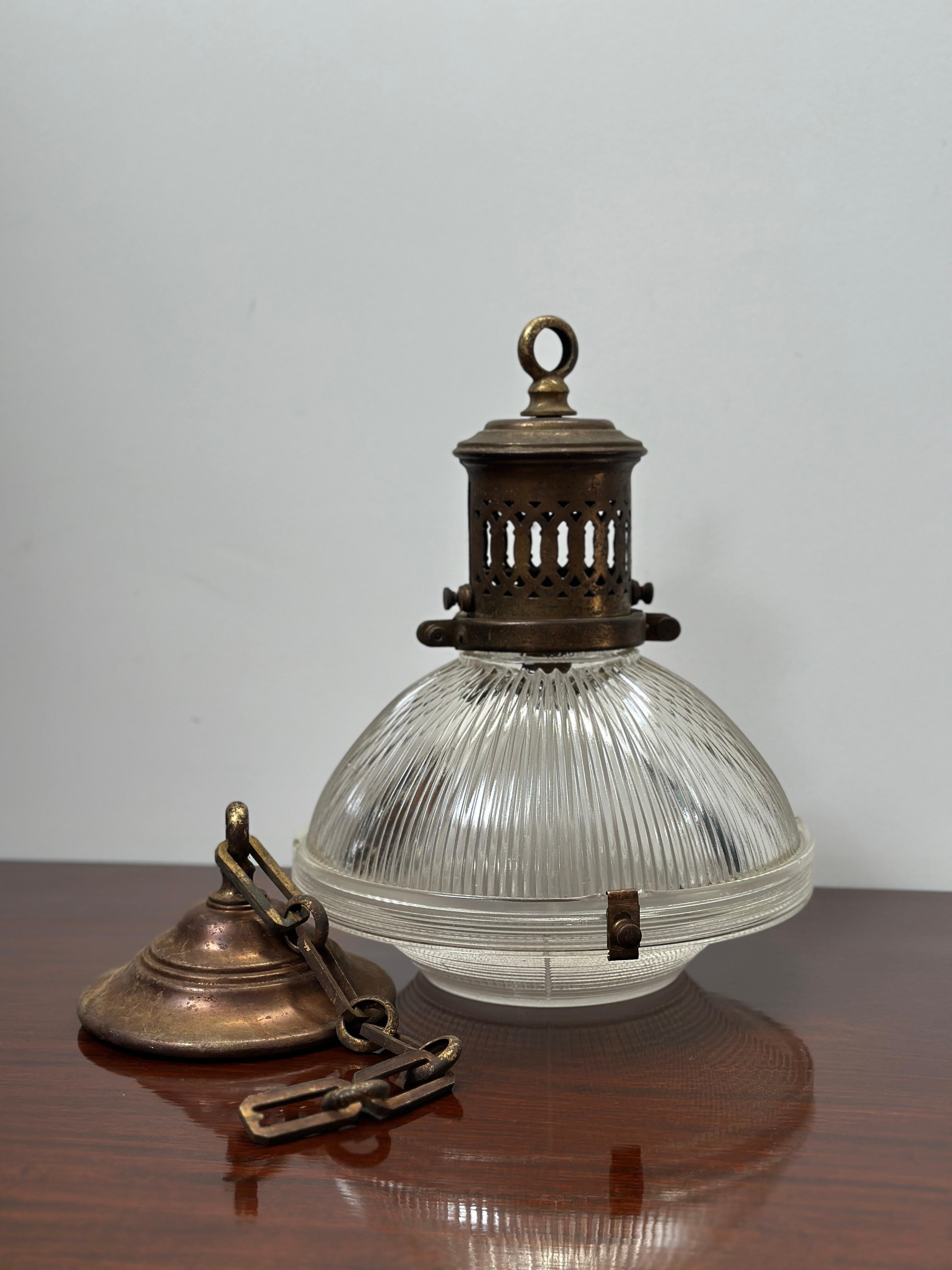 - Un bellissimo e rarissimo pendente da soffitto in vetro Holophane con catena e rosone originali, Francia, circa 1920.
- Galleria in ottone pesante che ospita due sezioni di vetro prismatico, stampigliato Holophane.  Due clip originali di Holophane