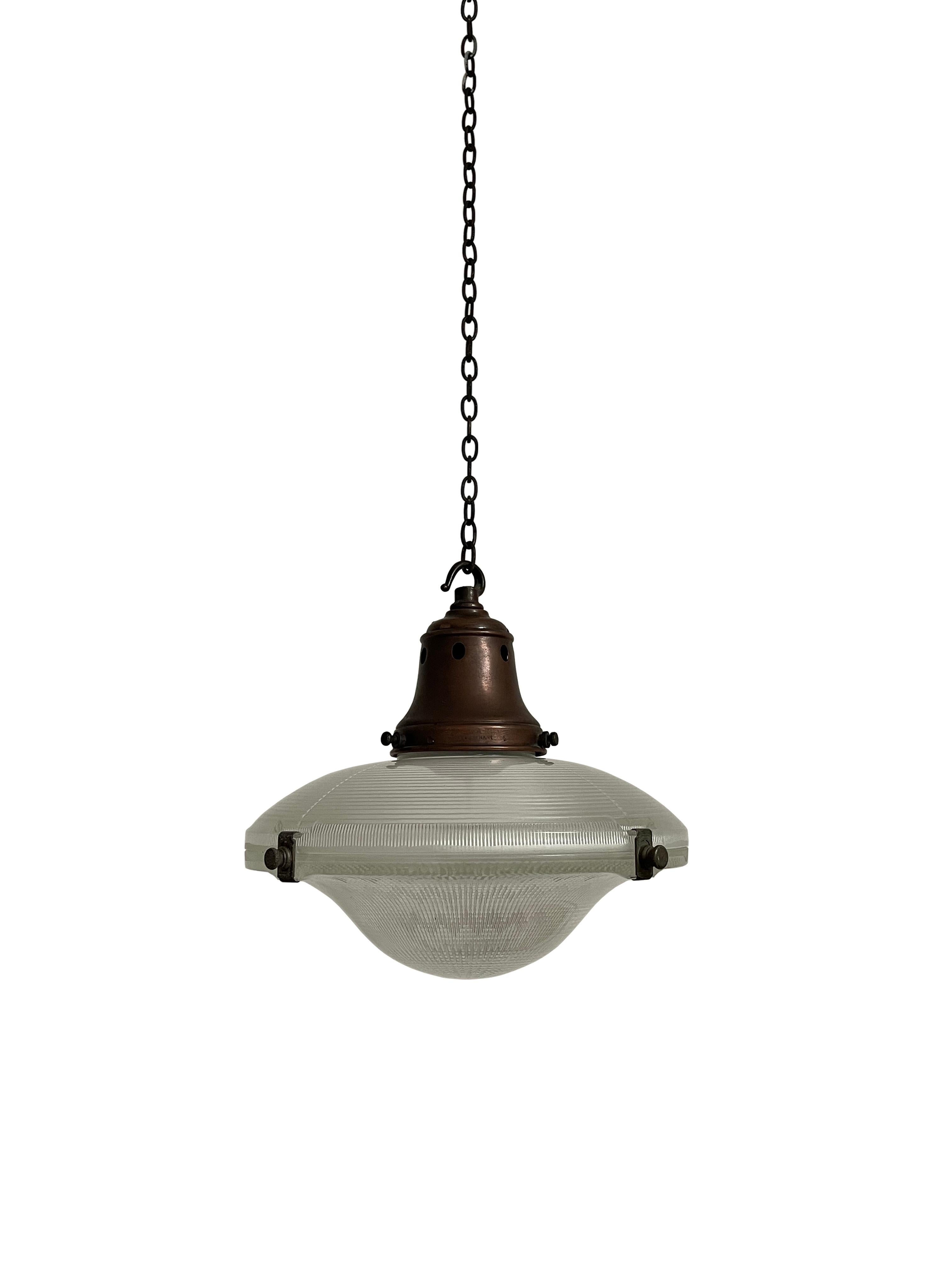 - A single 'Ripple-Lite' Holophane ceiling pendant with original stamped copper gallery, England circa 1910.
- The light comprises of two prismatic glass saucers held together by their original Holophane clips, across the upper section aged hooked
