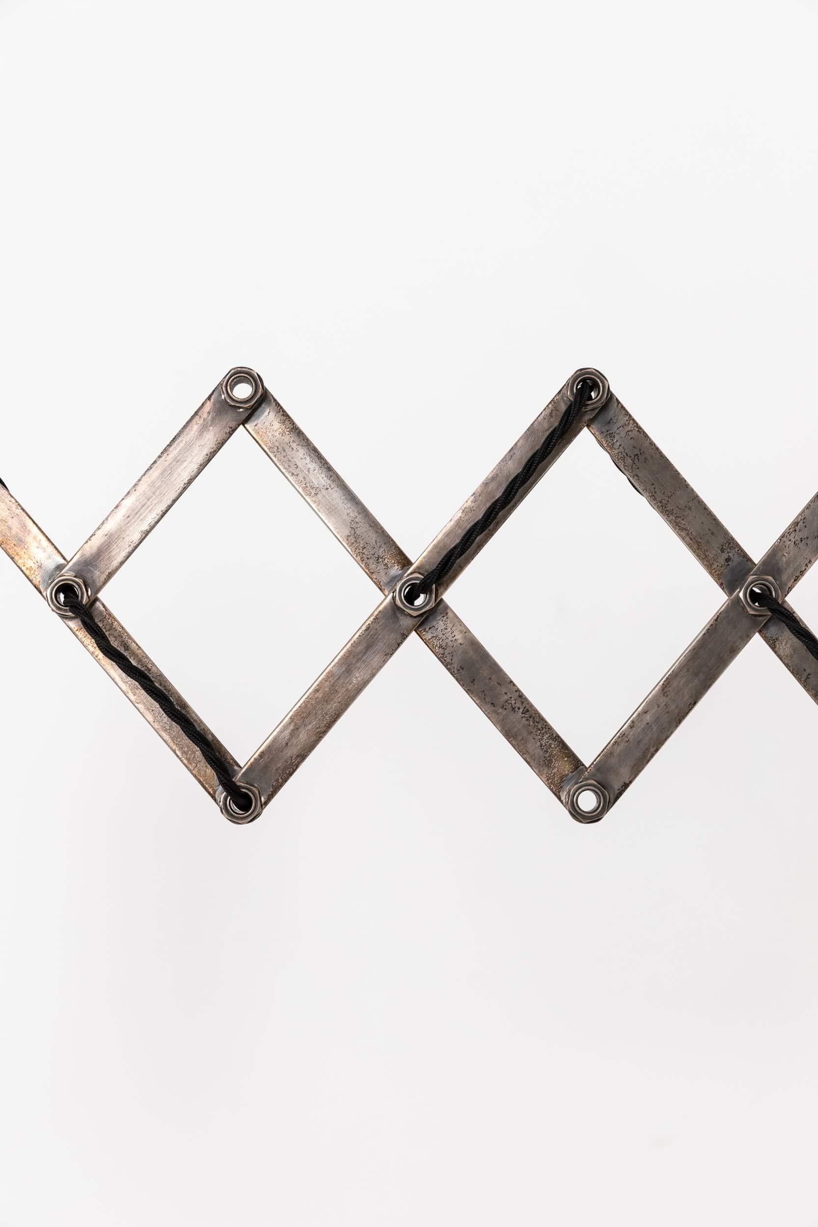 

Une très belle lampe à ciseaux nickelée. C.C.C.

Construction solide et de qualité, comprenant un support mural moulé et un abat-jour en métal filé.

Recâblé avec 2 m de câble rond noir et une fiche BS à 3 broches.
