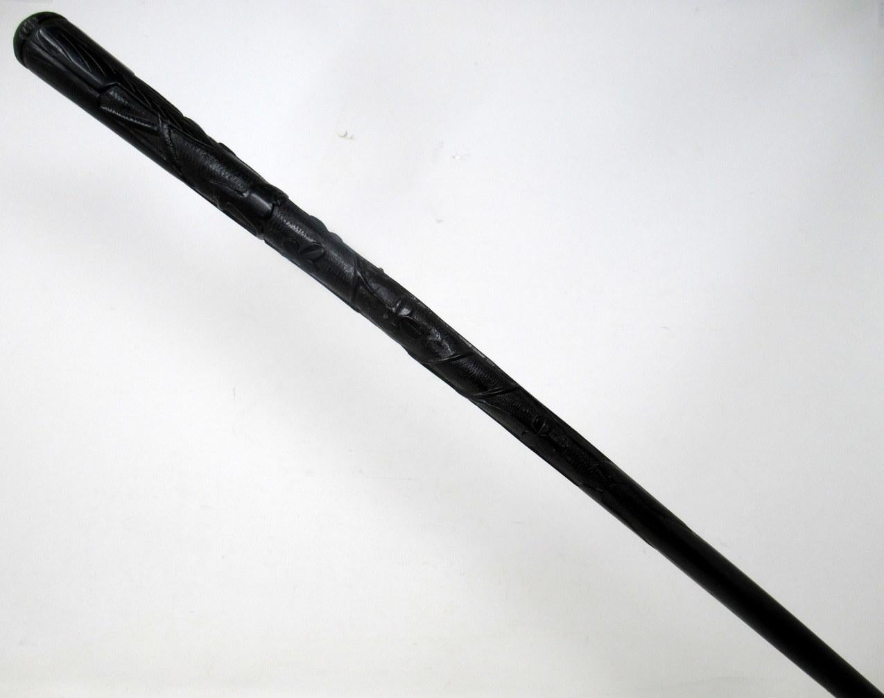 Stylish hand carved Irish Bog oak lady’s or gentleman’s swagger or walking stick, mid to late nineteenth century.  

The unusually long tapering grip finely carved depicting Shamrocks, Vine Leaves, a Round Tower, an Irish Harp and Laurel