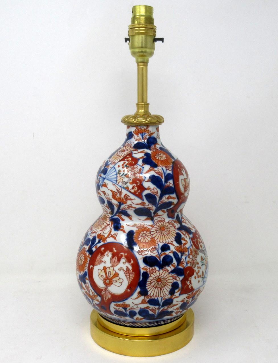 Stunning Traditional Japanese Imari hand decorated Porcelain double gourd form glazed porcelain, of medium proportions, now converted to an electric Table Lamp, complete with later plain heavy-duty Ormolu circular stepped base. Third quarter of the