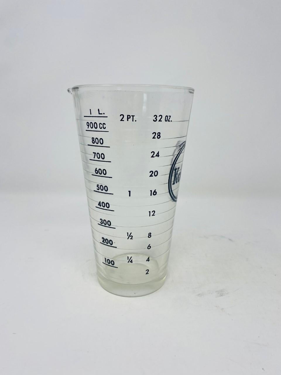 Vintage 1940s glass Kodak developer beaker. This amazing piece is minimal and cool, and features a large 32 ounce capacity for holding and measuring liquids. Used primarily in dark rooms for photo developer solution, this beaker would be a great