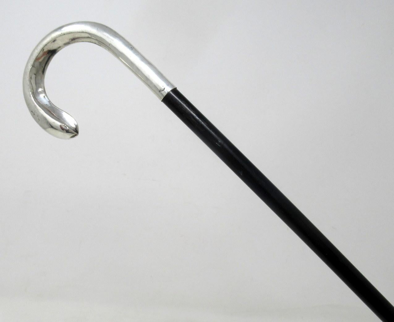 Stylish solid polished ebony and sterling silver lady’s walking stick with traditional plain cast crook shaped handle, complete with its original bi-metal polished brass and steel ferrule, which is very lightly worn from use. 

Makers Mark is